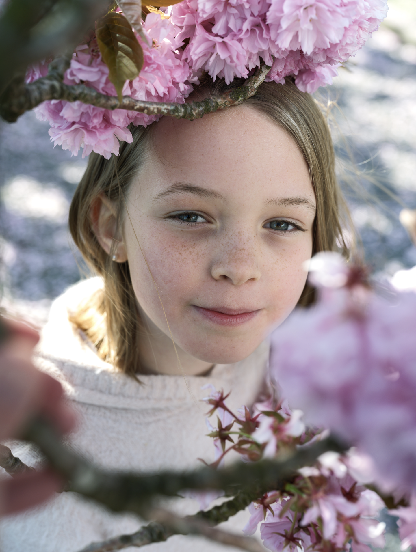 Une jeune fille admire des fleurs roses de cerisier en fleurs.