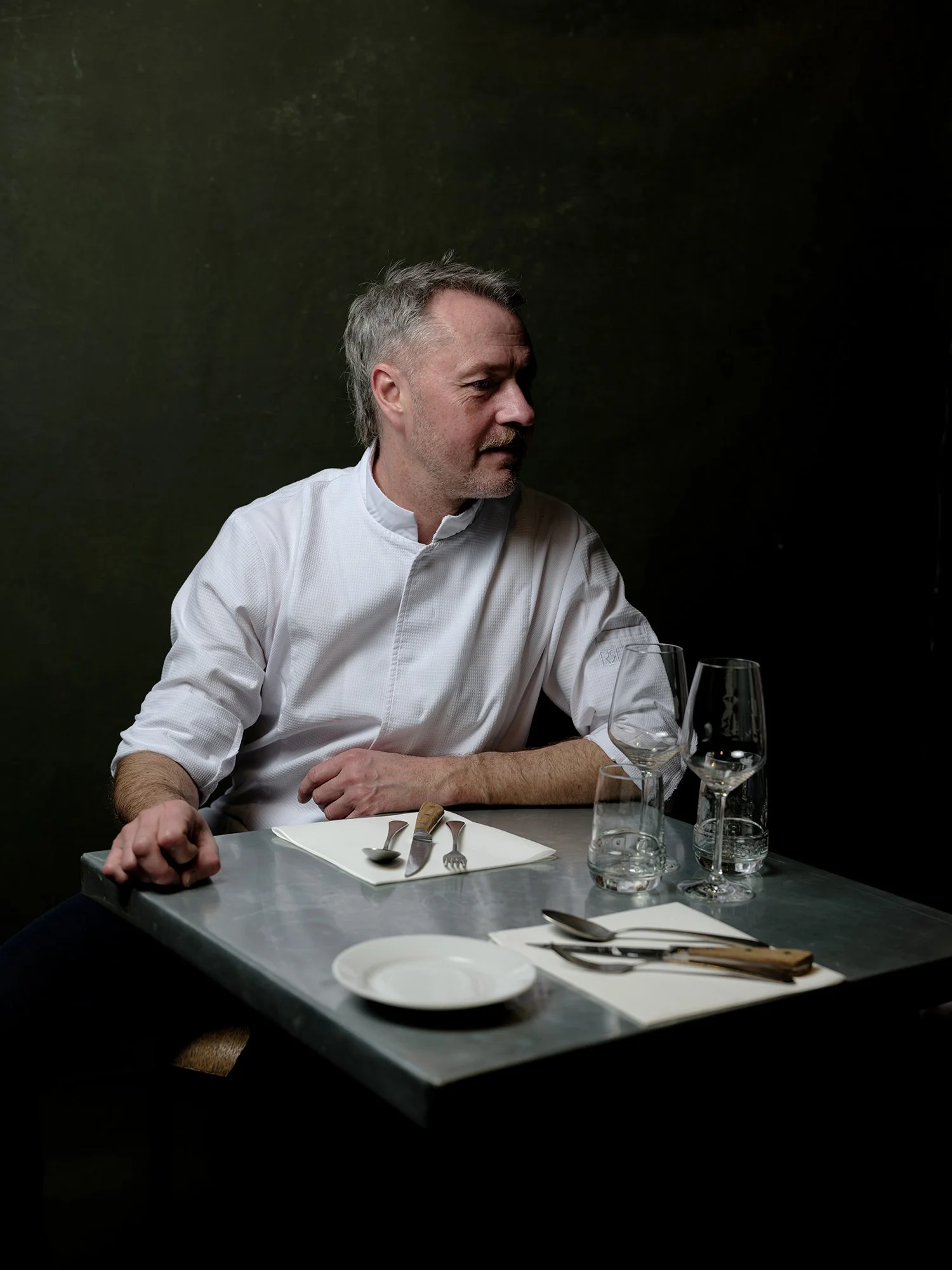 Portrait du chef Benoît à la Guinguette, photographié en ambiance restaurant avec éclairage directionnel mettant en valeur l’expression et la matière.