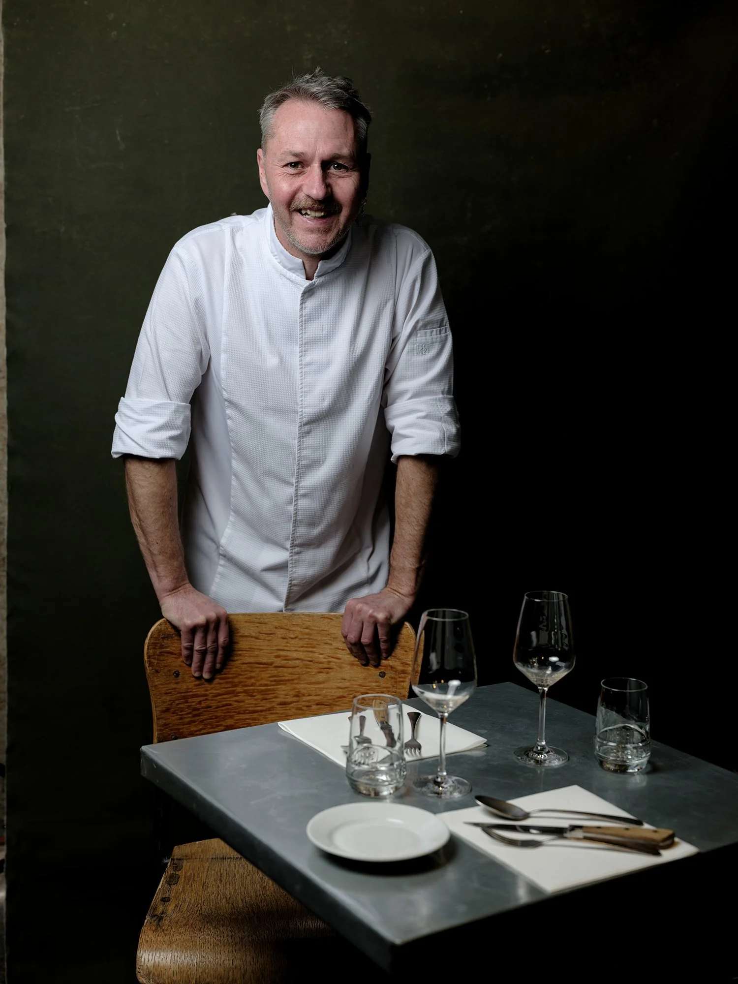 Portrait du chef Benoît à la Guinguette, photographié en ambiance restaurant avec éclairage directionnel mettant en valeur l’expression et la matière.