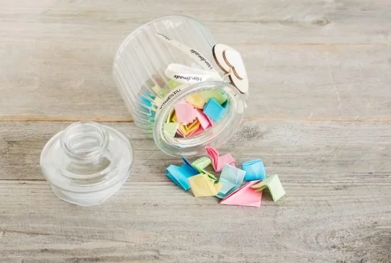 a jar with small colorful pieces of paper inside