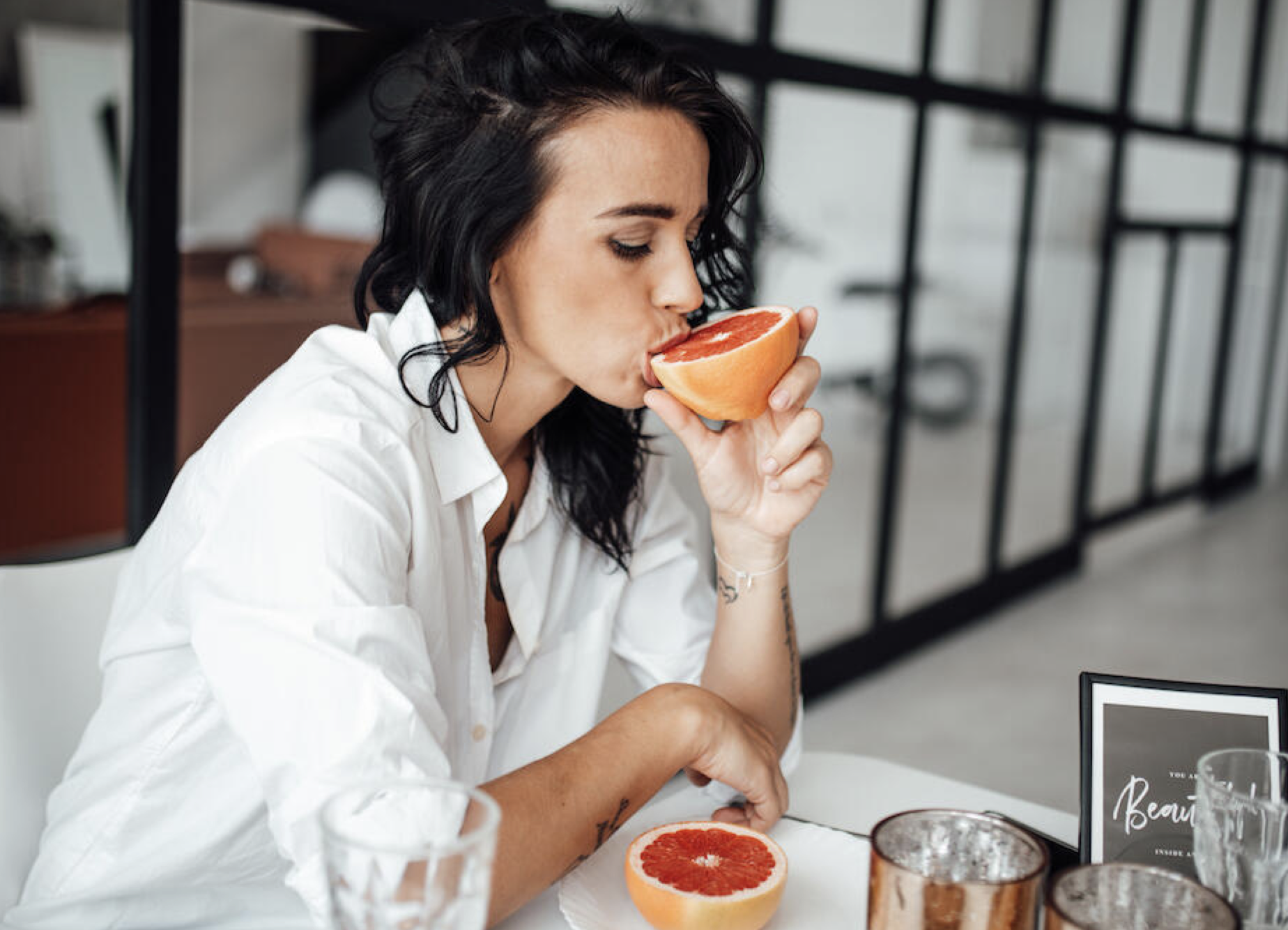 image of woman eating grapefruit for vitamin C