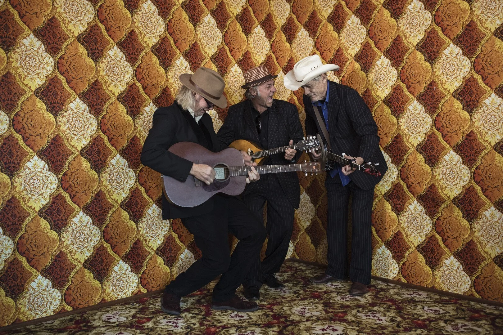 Still image from the film "That Half Barbaric Twang" showing the three main cast members playing stringed instruments together