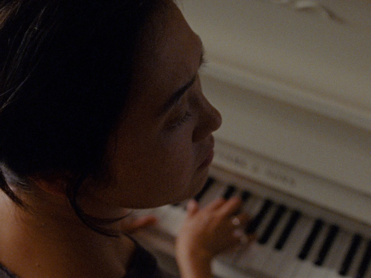 Still image from the film "Some Kind of Blue" showing a woman playing a piano