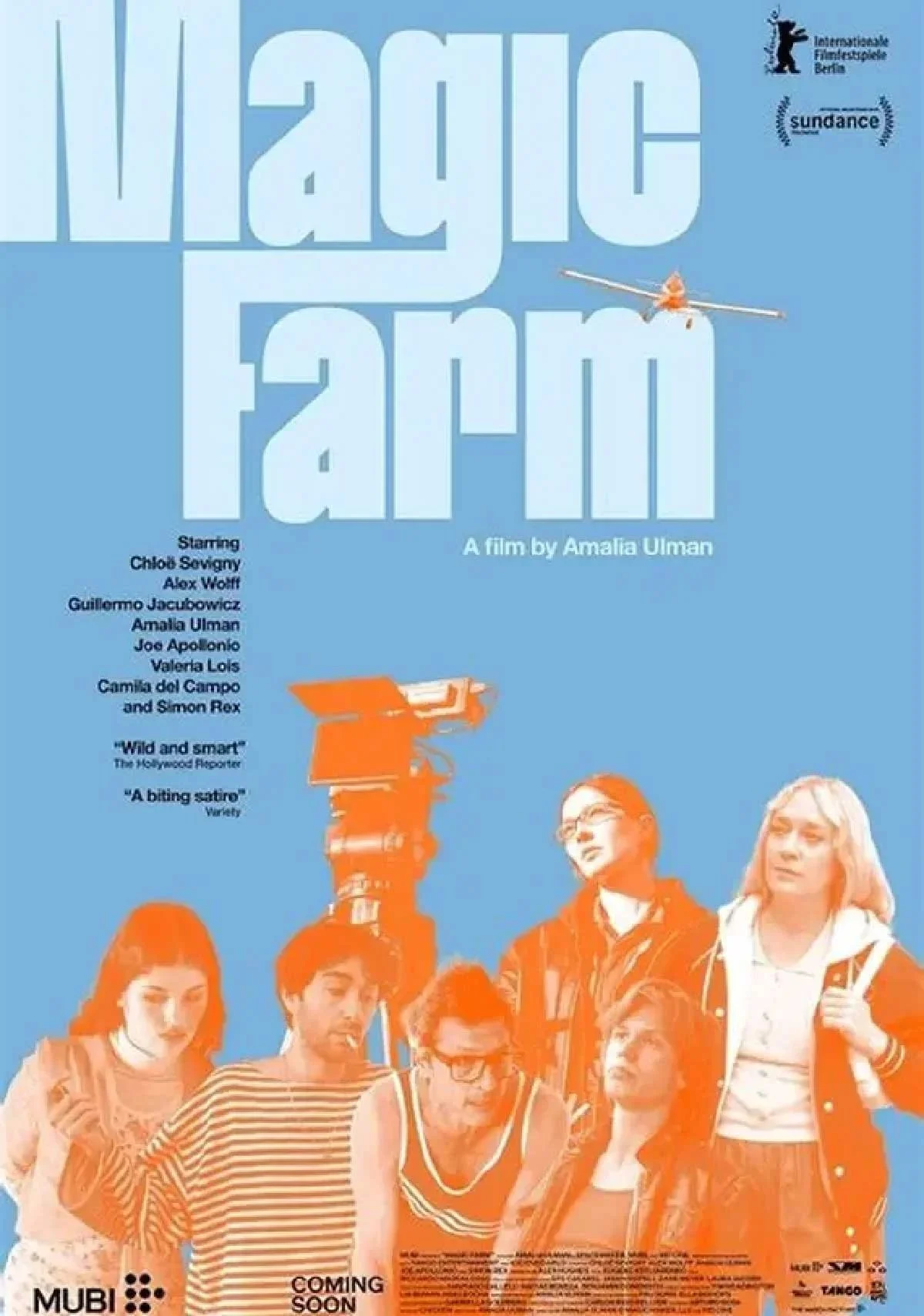 A film poster with a blue background and the title “Magic Farm” above a group of orange-tinted people gathered around a tall camera rig.