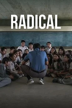 A teacher or adult speaking to a group of children seated on the floor in a classroom with the word 'RADICAL' written above them.