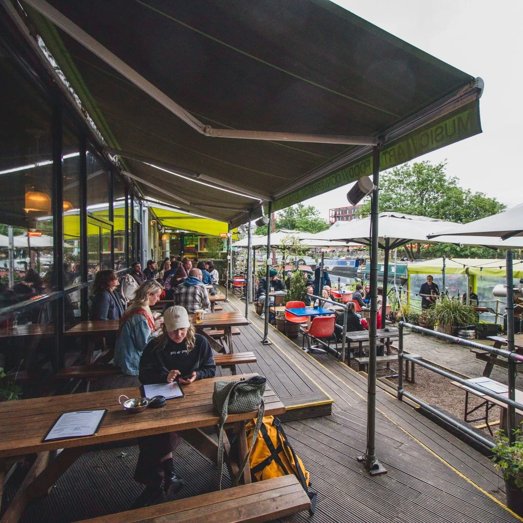 Outdoor terrace seating by the River Lea at Grow Hackney