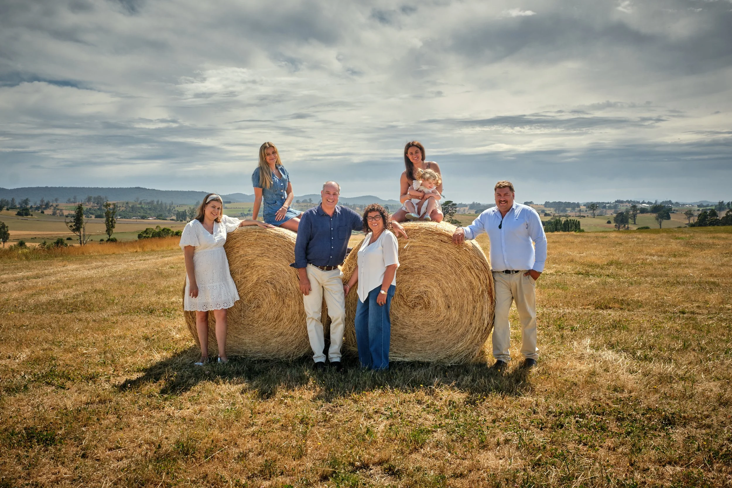 clark-launceston-extended-family-farm-portrait-on-hay-bales-in-paddock.jpeg