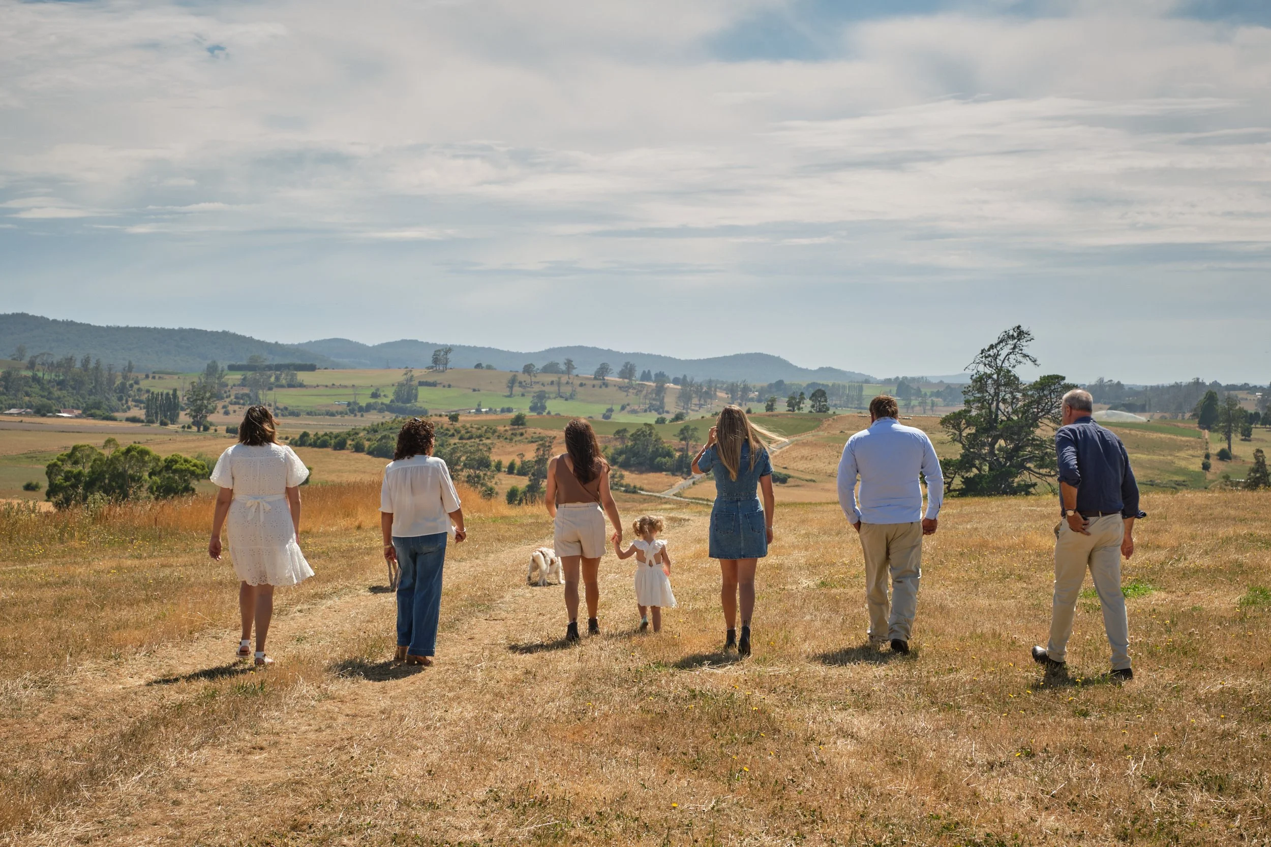 clark-launceston-extended-family-walking-across-farm-fields-with-child-and-dog.jpeg