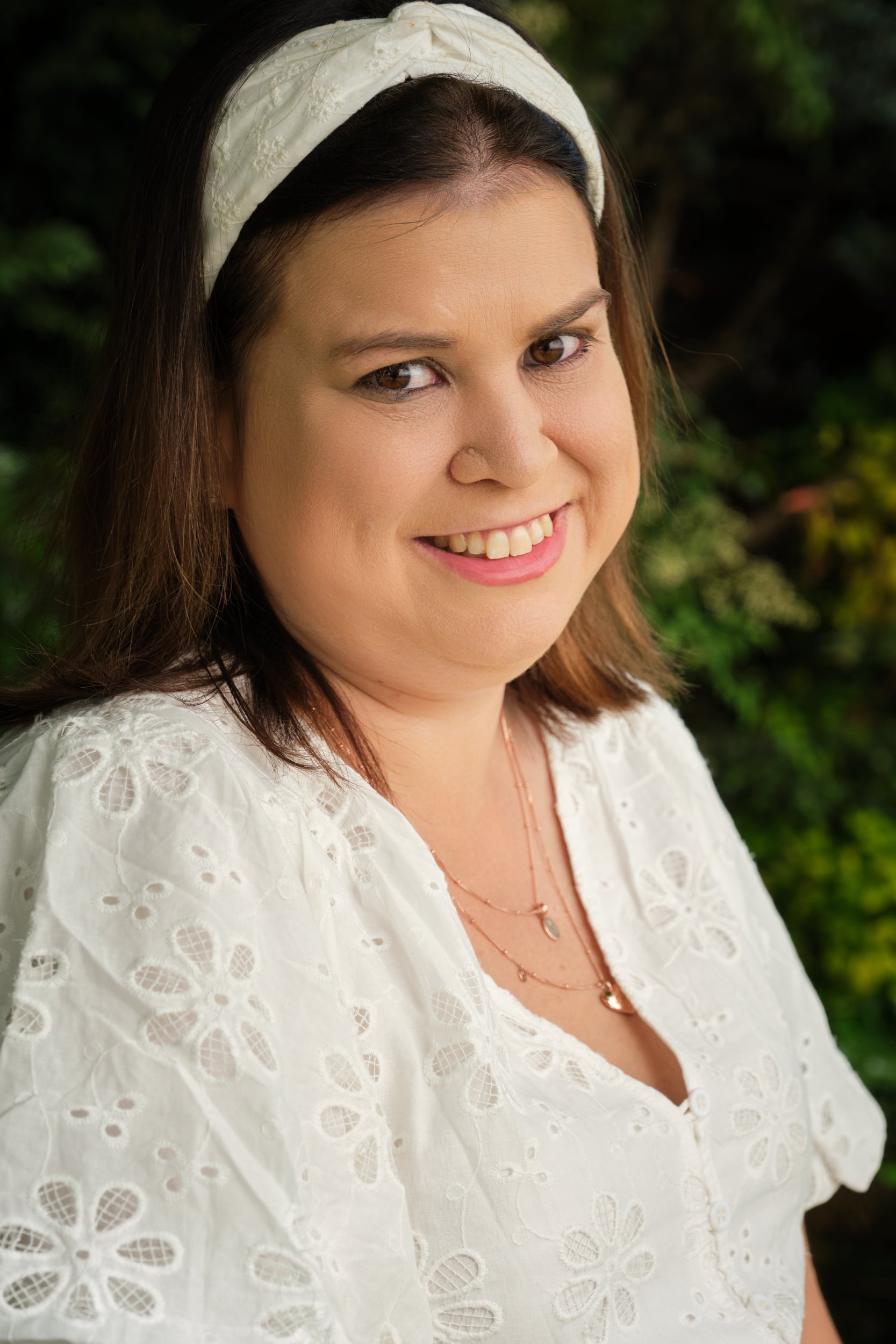 clark-launceston-extended-family-woman-smiling-white-dress-garden-backdrop.jpeg
