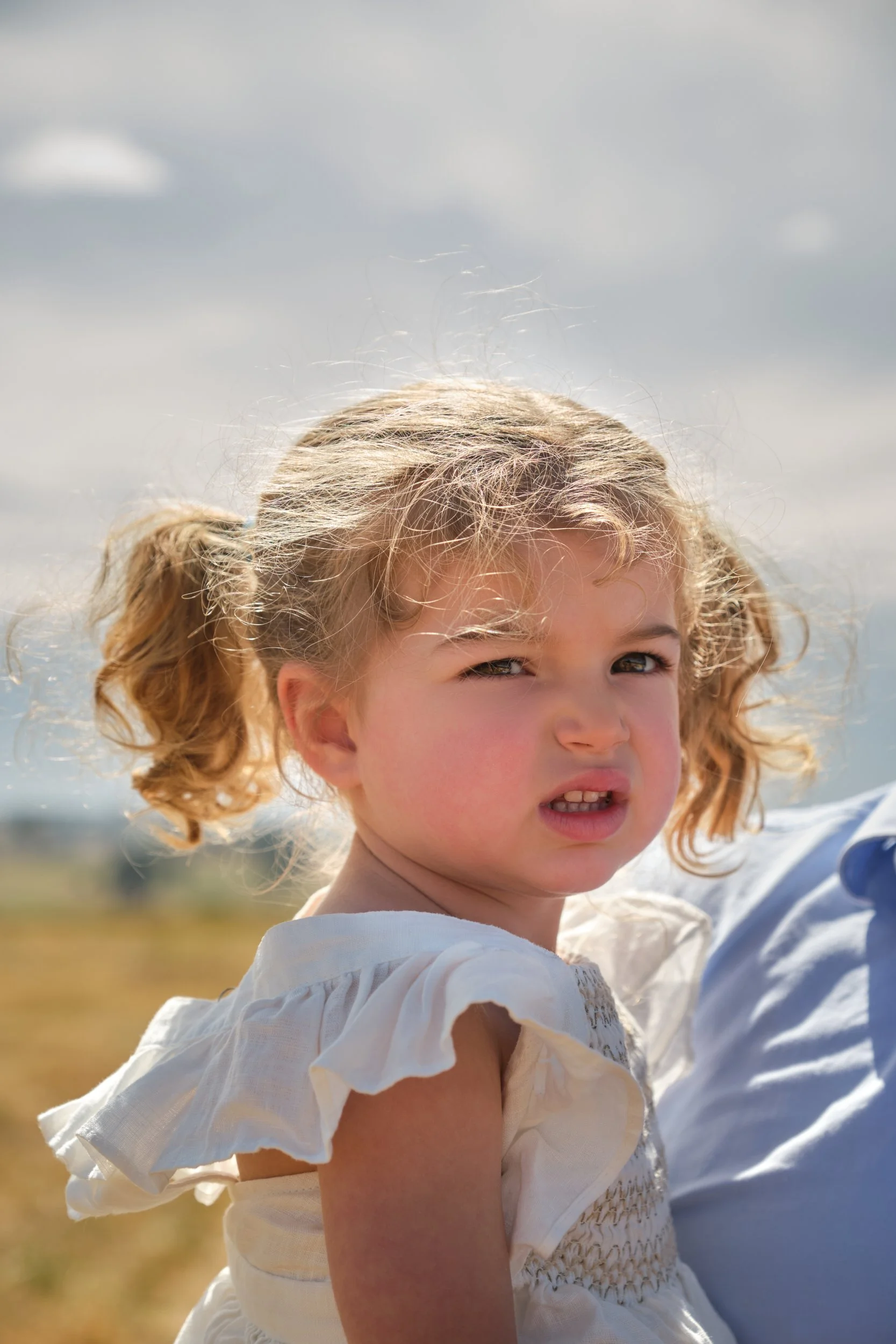 clark-launceston-extended-family-young-girl-pigtails-squinting-sunny-field.jpeg