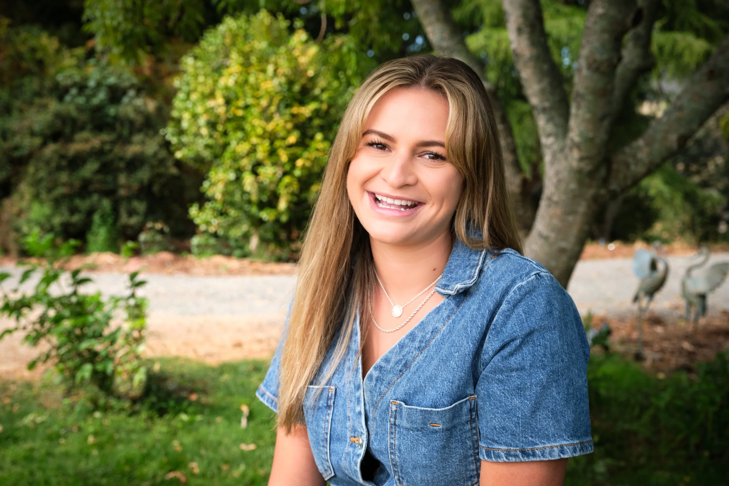 clark-launceston-extended-family-young-woman-smiling-outdoors-garden-tree-backdrop.jpeg