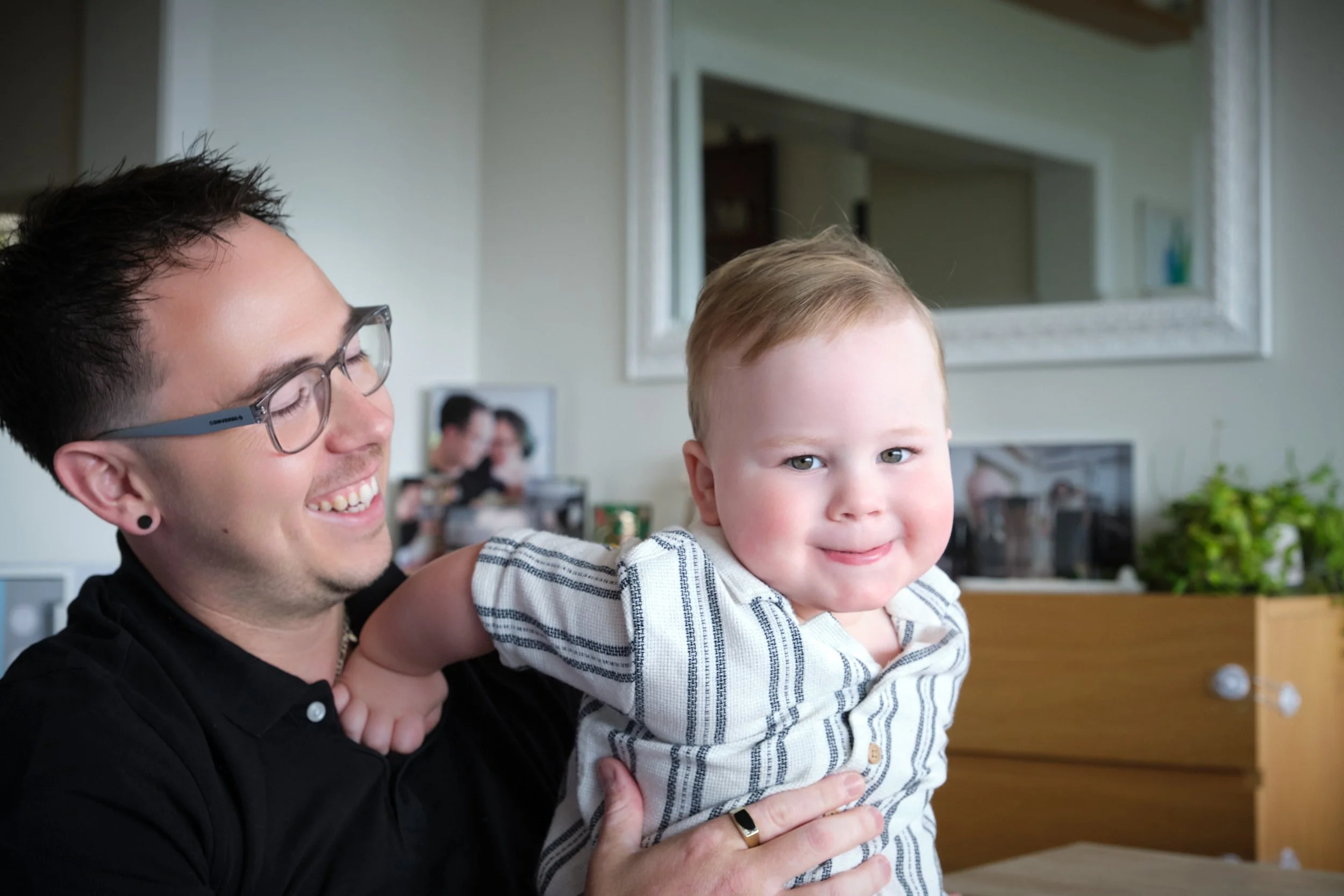 petty-riverside-family-portrait-dad-holding-smiling-baby-at-home.jpeg