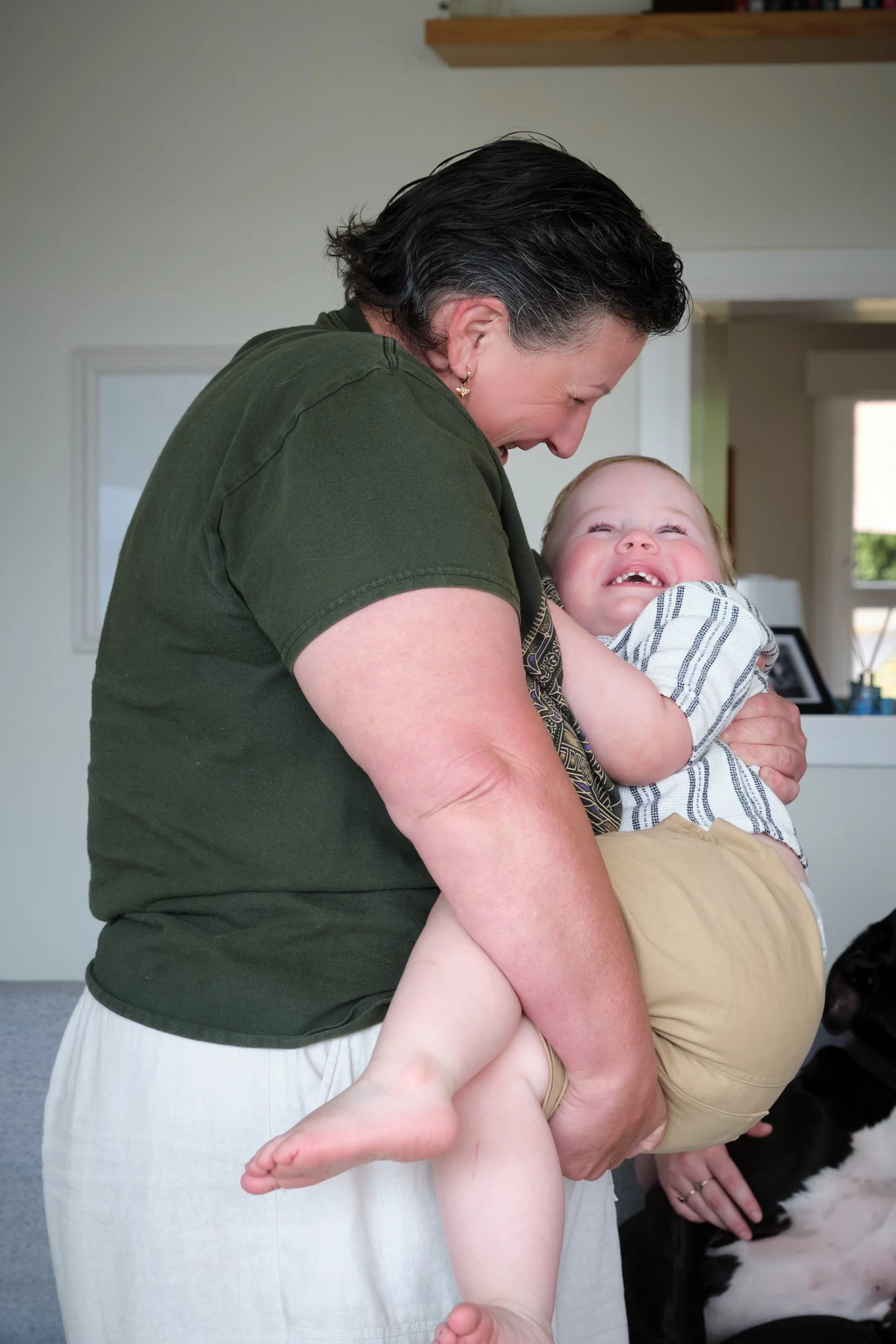 petty-riverside-family-portrait-parent-holding-laughing-toddler-at-home.jpeg