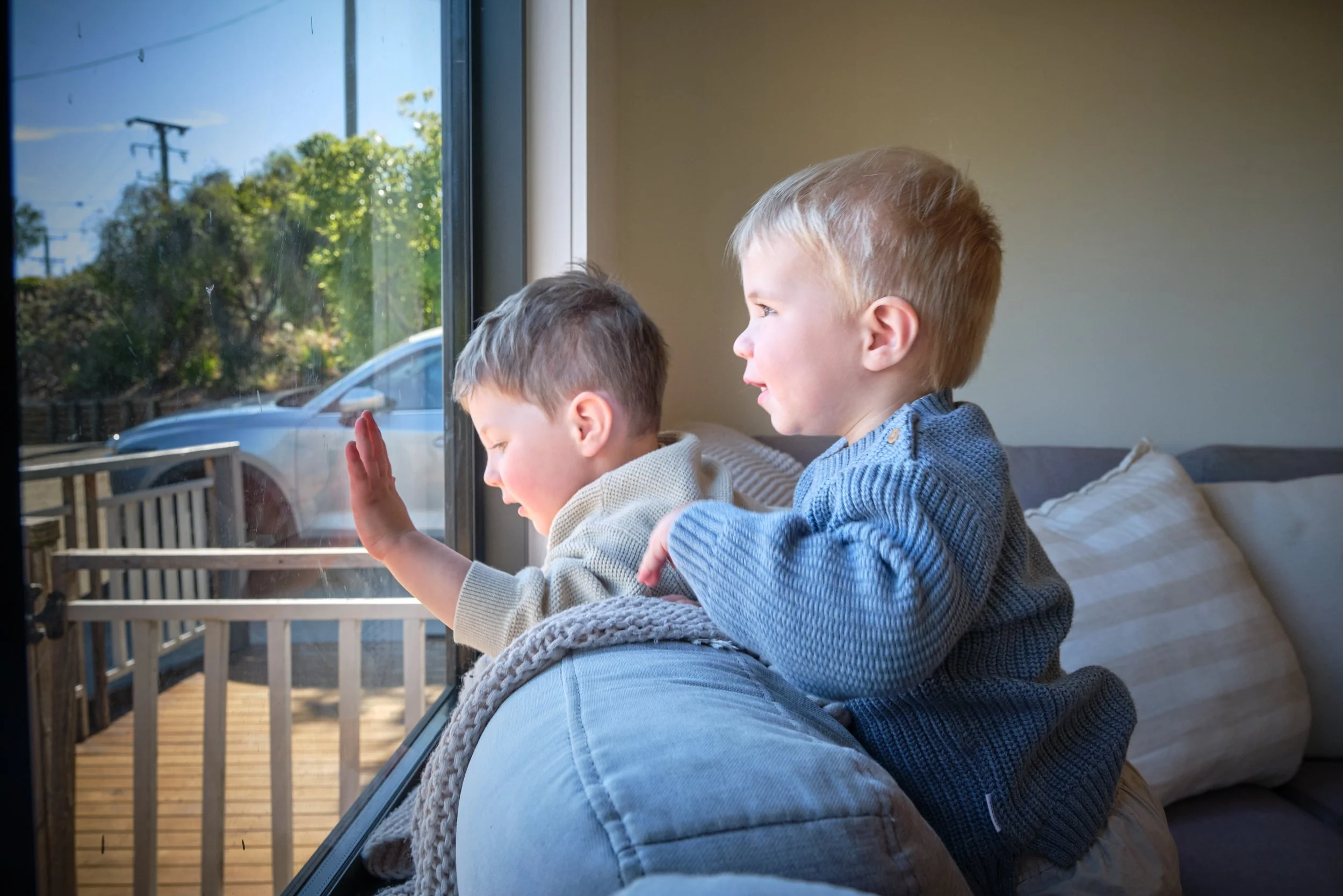macdonald-launceston-family-photography-toddlers-looking-out-window-couch-playful-moment.jpeg