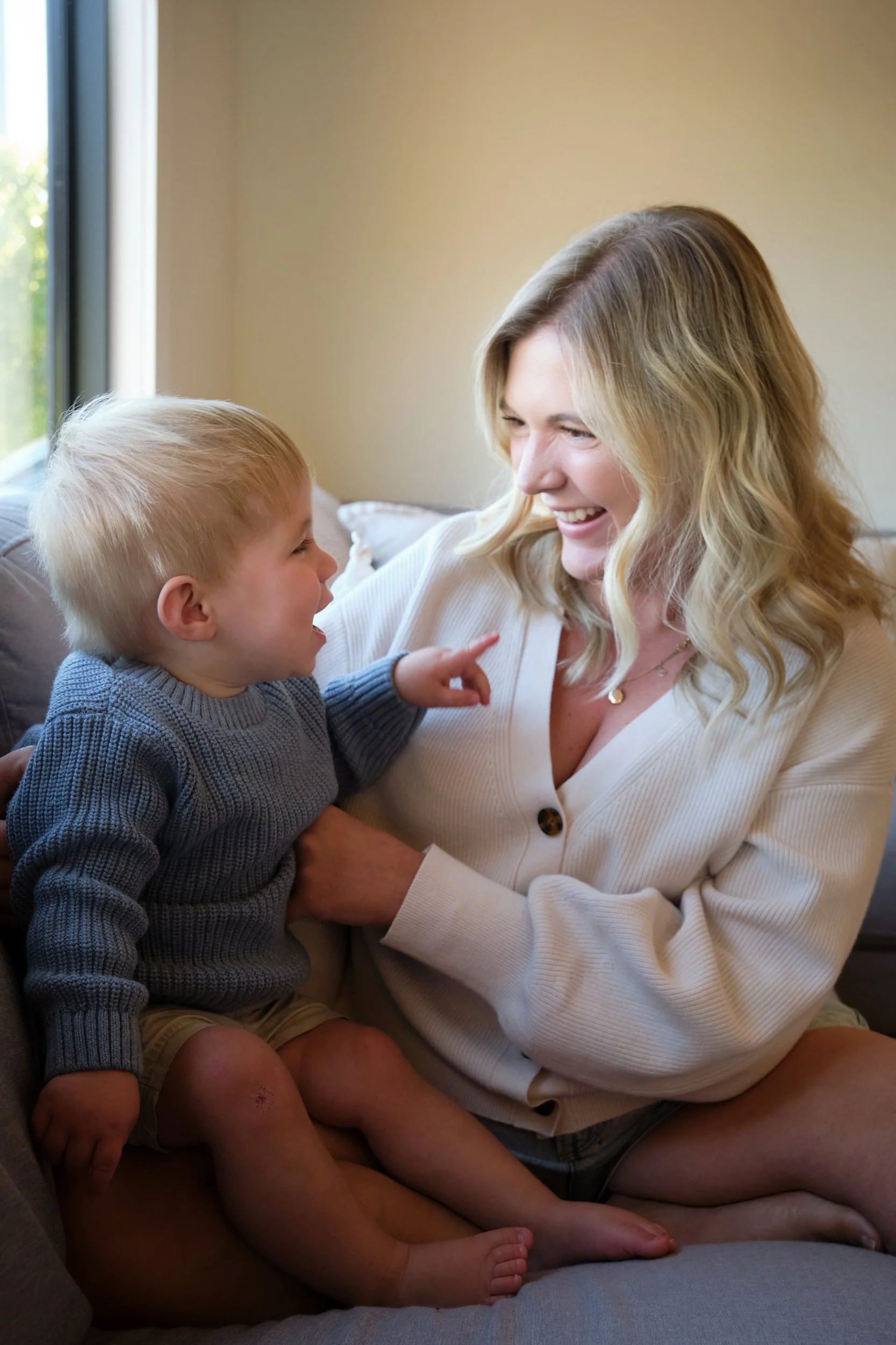 macdonald-launceston-family-portrait-mother-and-toddler-laughing-on-couch.jpeg