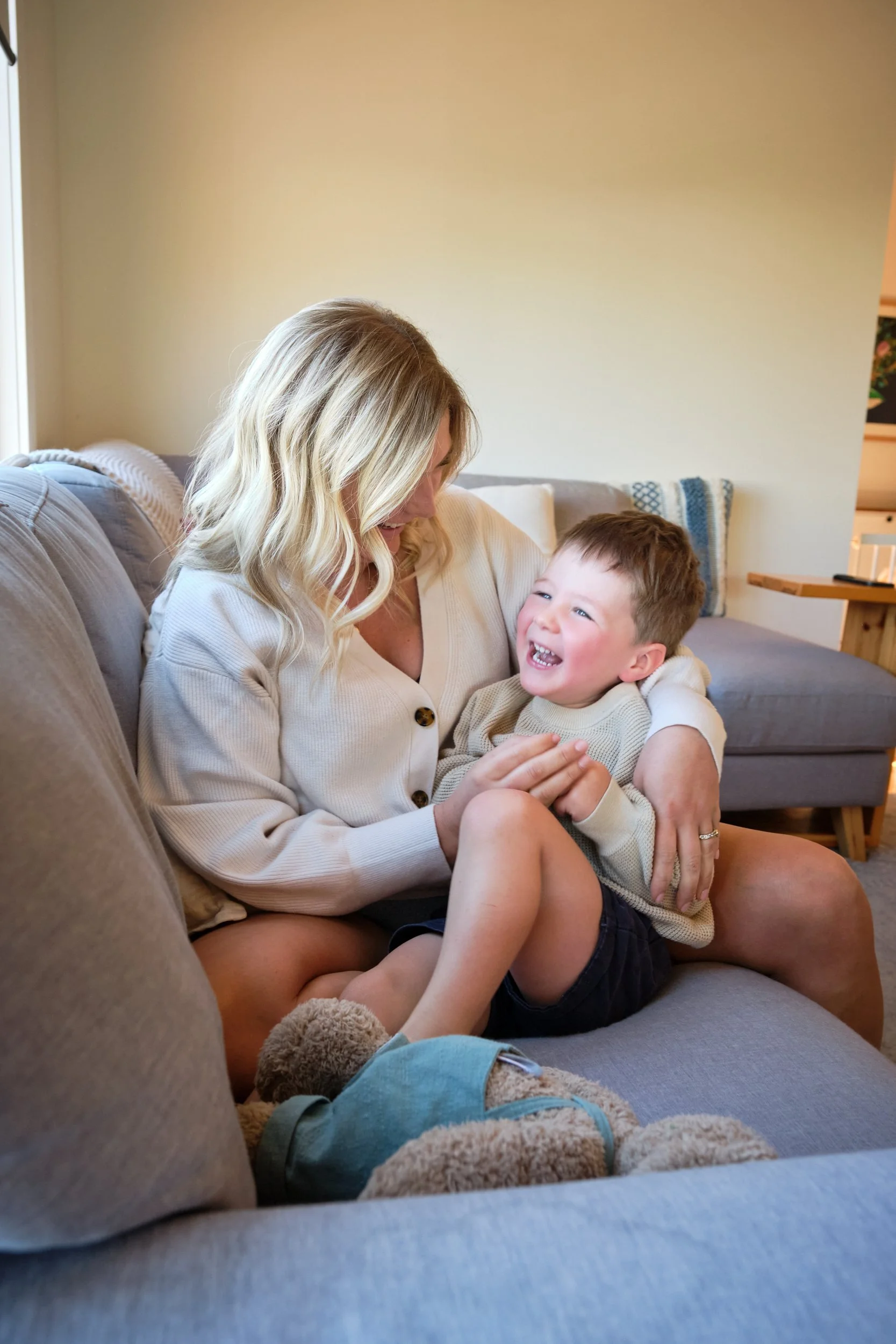 macdonald-launceston-family-portrait-mum-cuddling-laughing-son-on-couch.jpeg