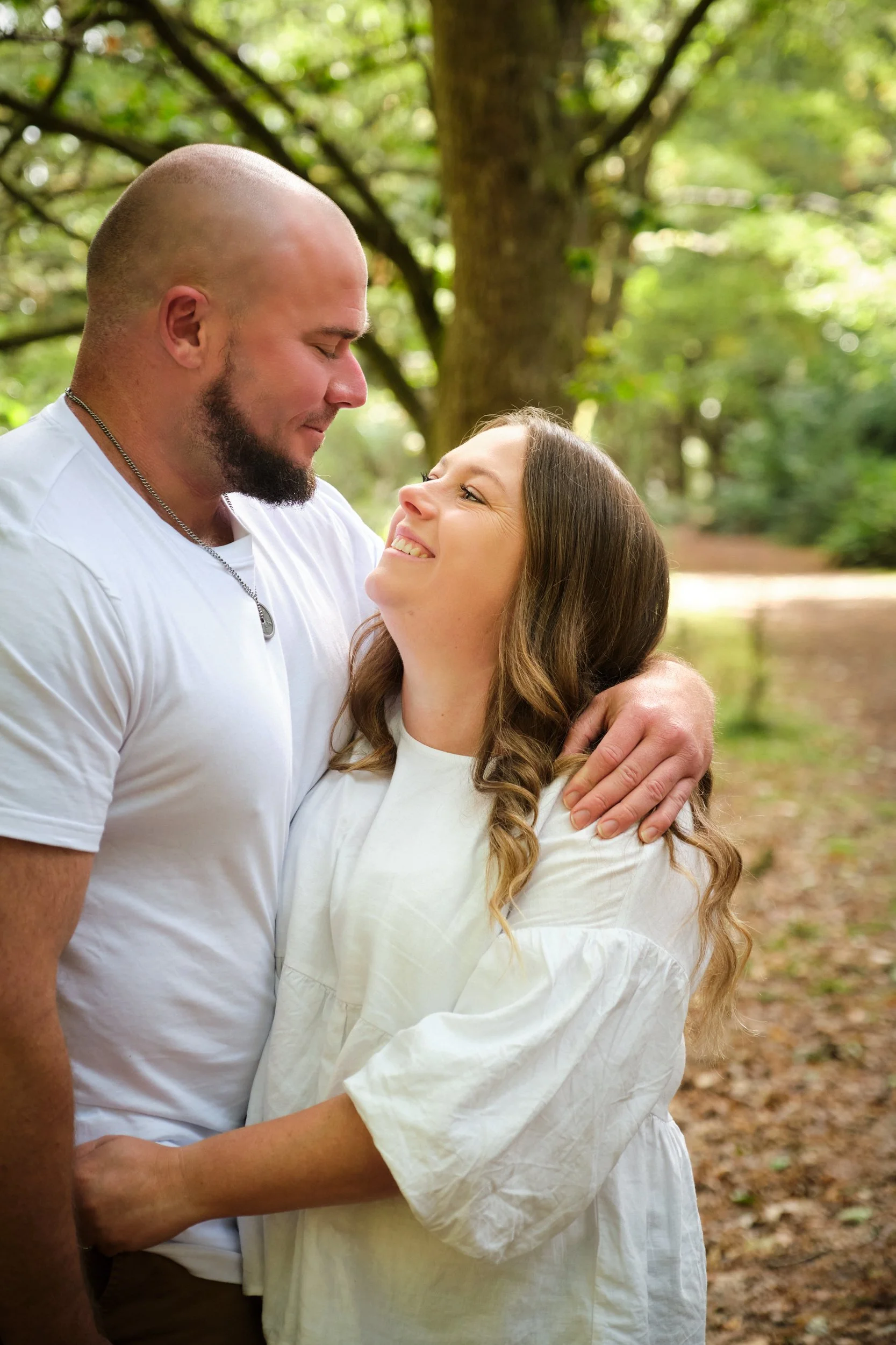 kearnes-hollybank-launceston-family-portrait-photography-couple-smiling-embrace-forest-path.jpeg