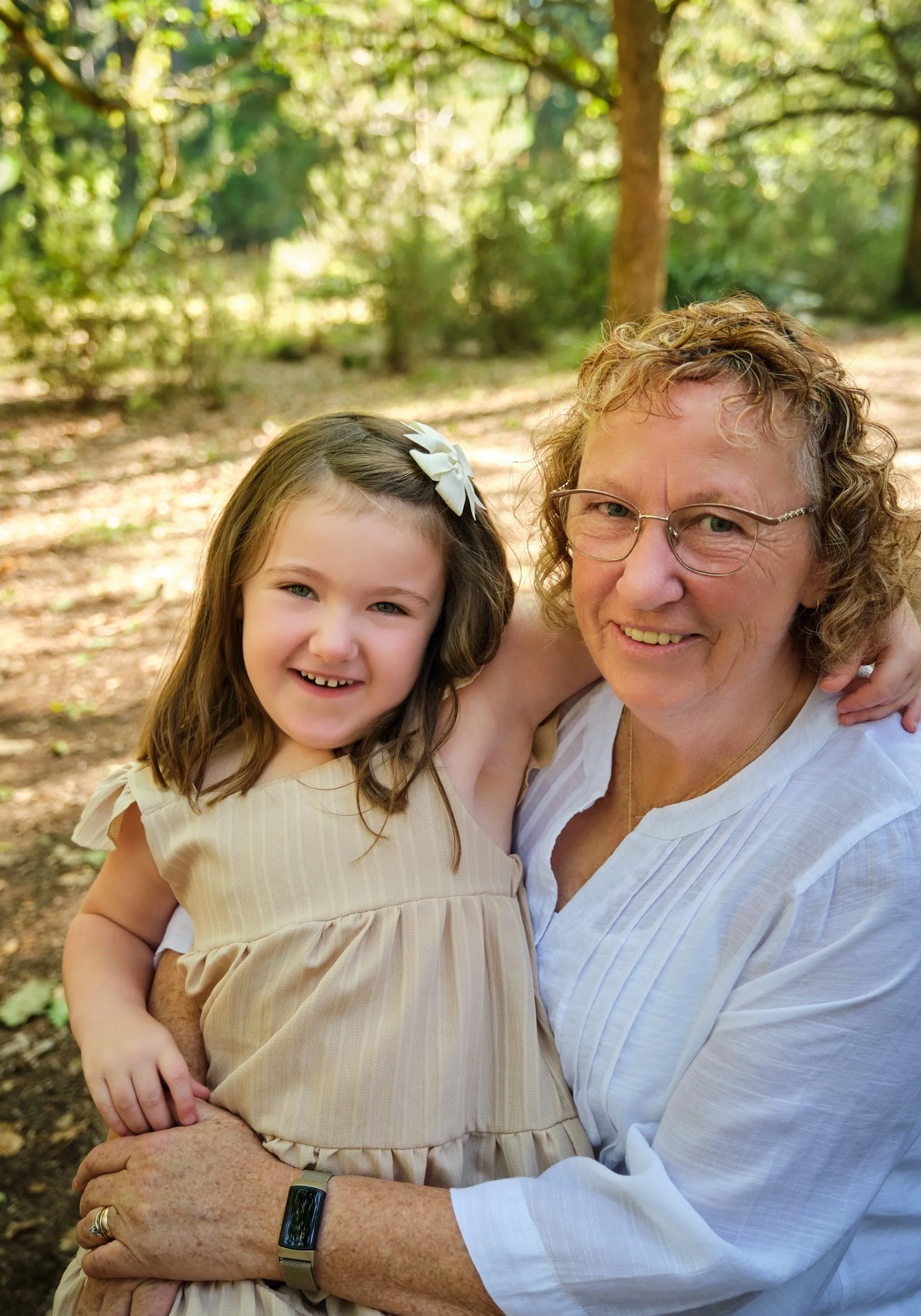 woods-hollybank-launceston-extended-family-photography-grandmother-hugging-granddaughter-smiling-in-forest.jpeg