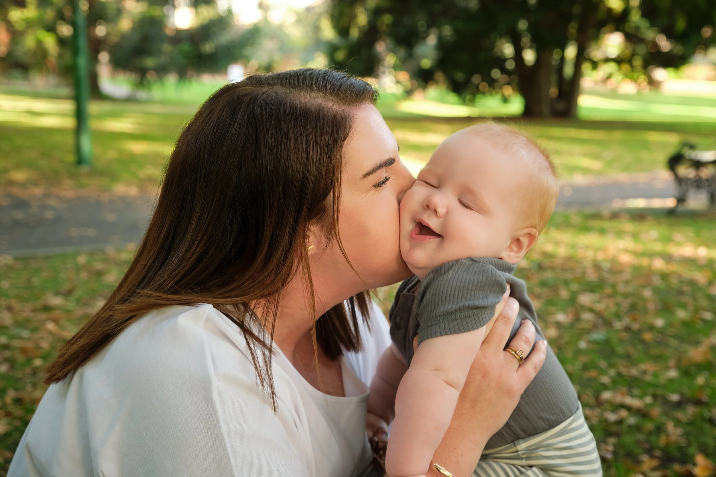 henderson-city-park-launceston-family-portrait-photography-mother-kissing-smiling-baby.jpeg