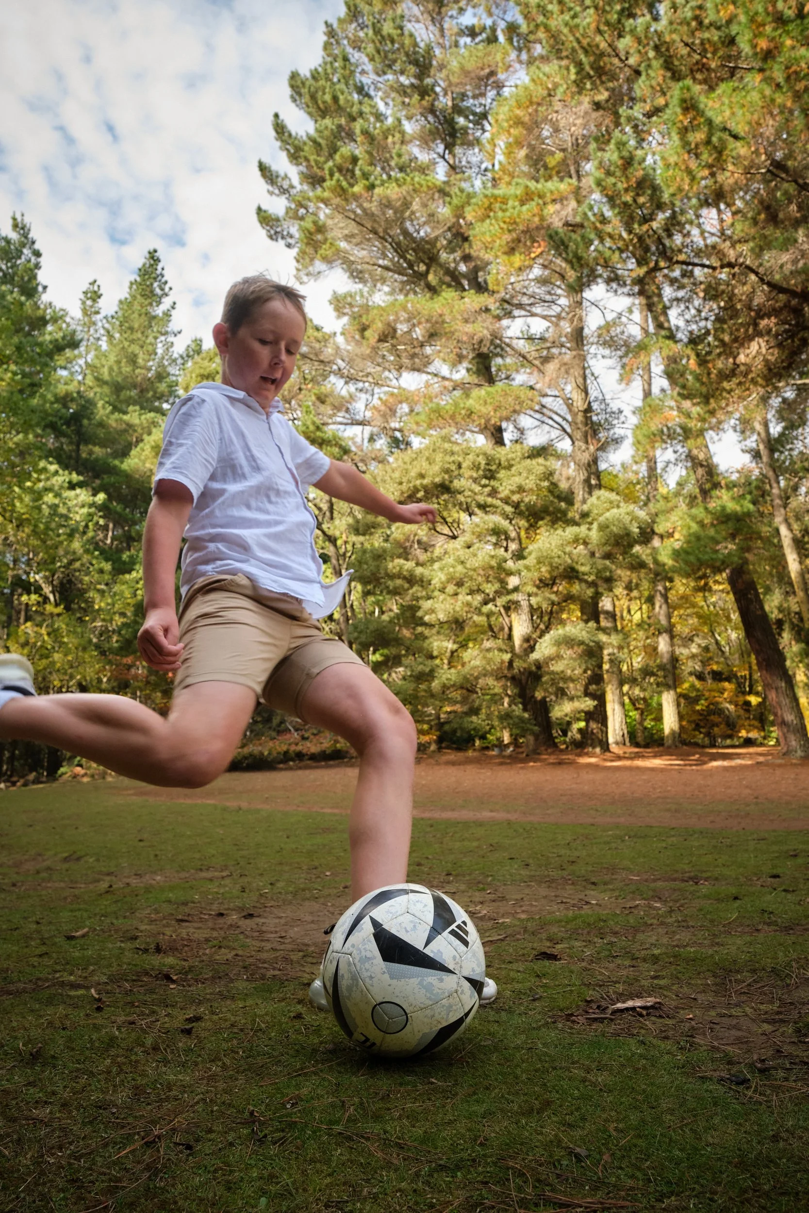 north-hollybank-launceston-family-photography-boy-kicking-soccer-ball-in-forest-2.jpeg