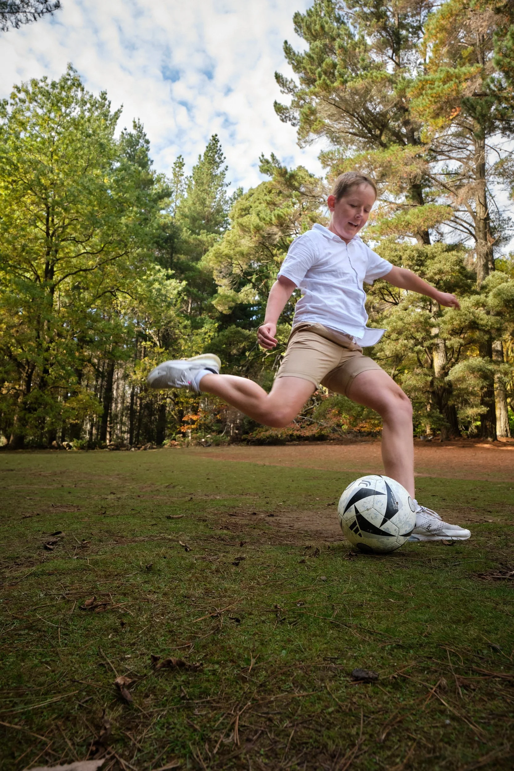 north-hollybank-launceston-family-photography-boy-kicking-soccer-ball-in-forest.jpeg