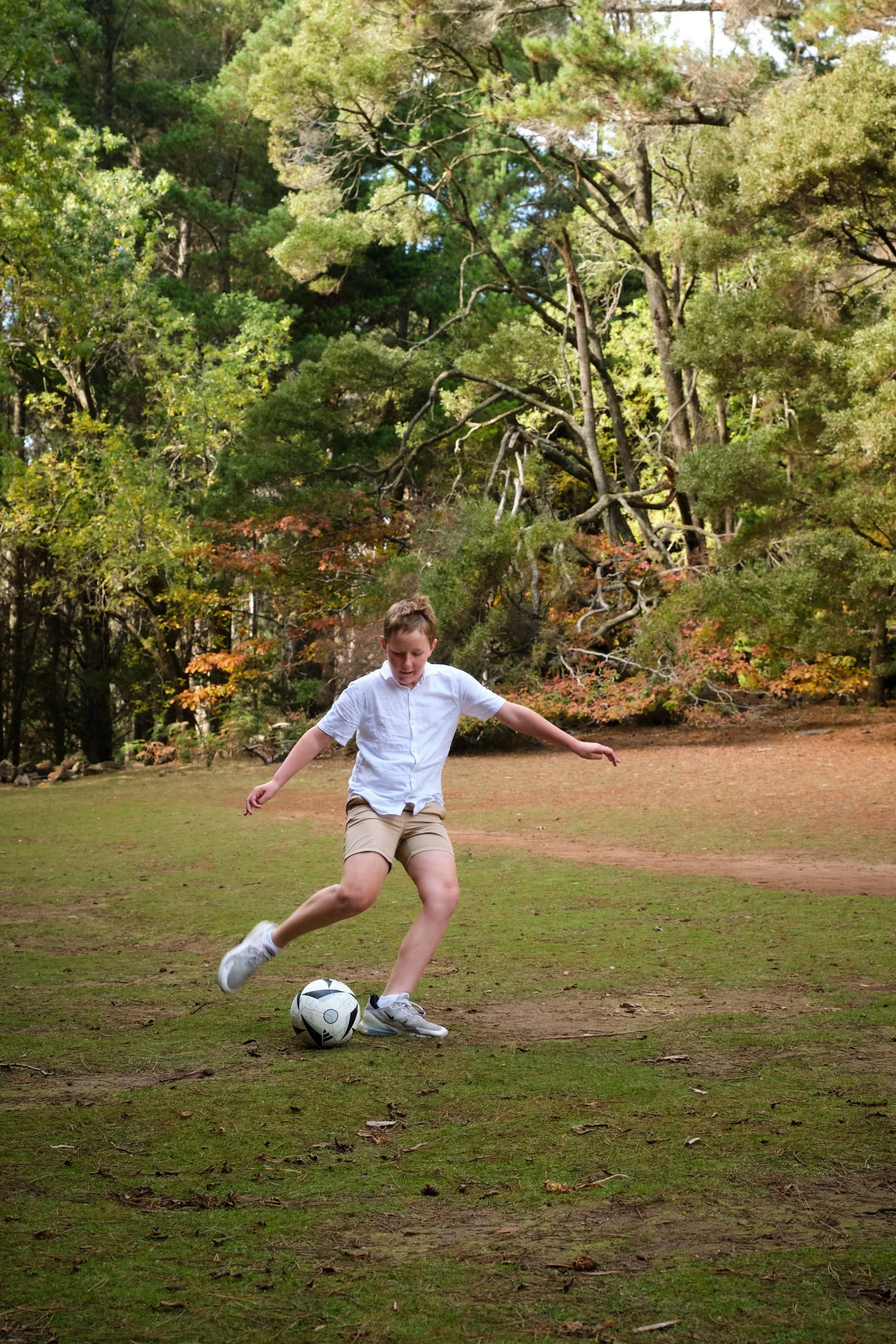 north-hollybank-launceston-family-photography-boy-playing-soccer-in-forest-clearing-2.jpeg