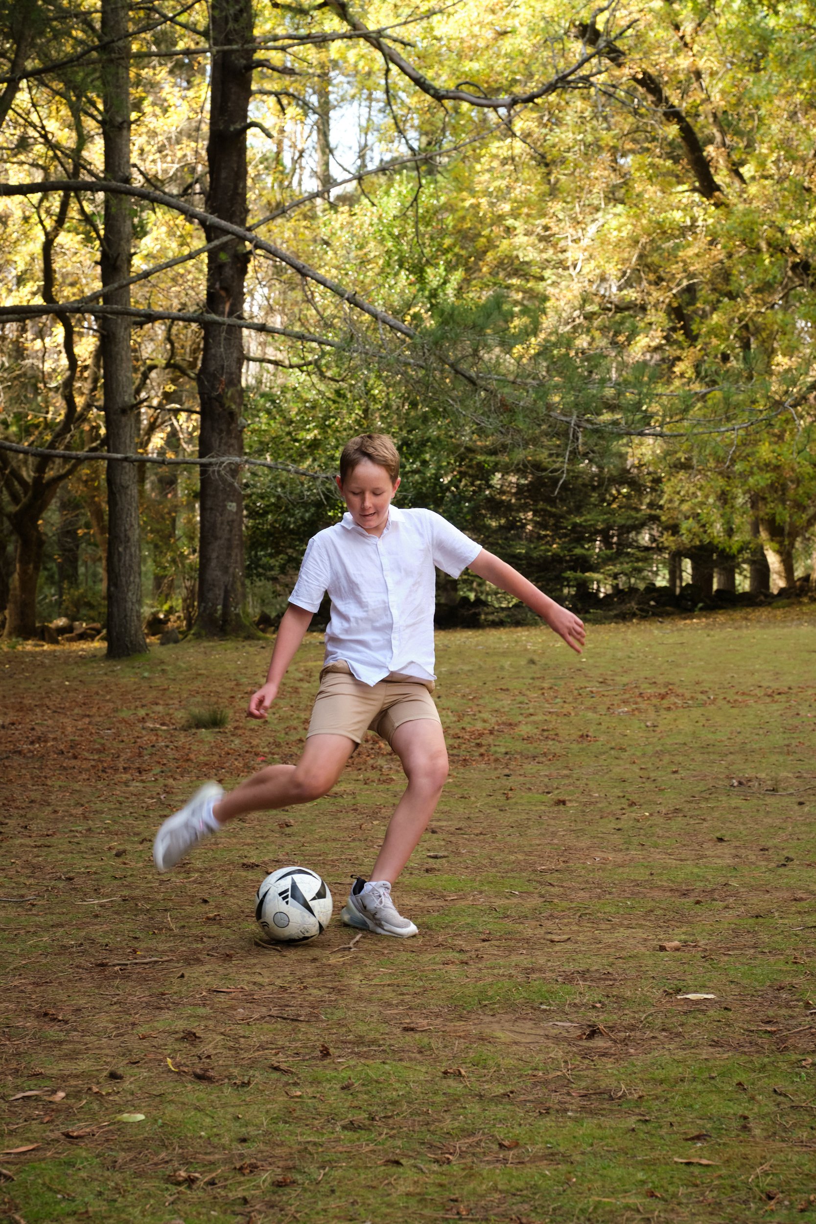 north-hollybank-launceston-family-photography-boy-playing-soccer-in-forest-clearing.jpeg