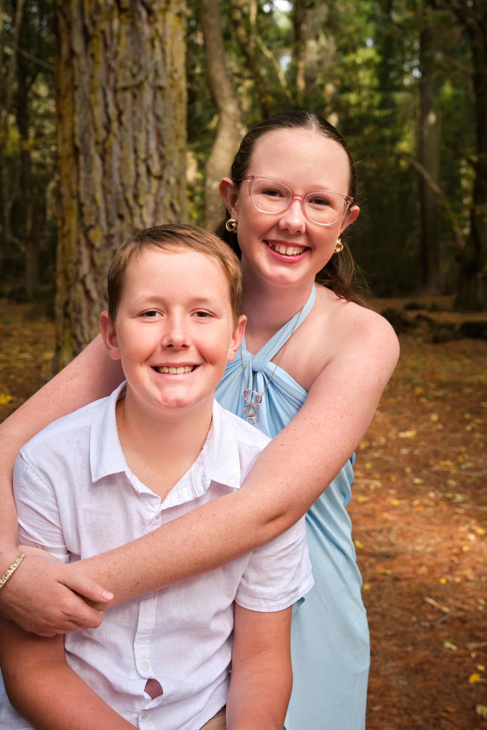 north-hollybank-launceston-family-photography-siblings-smiling-hugging-in-forest.jpeg