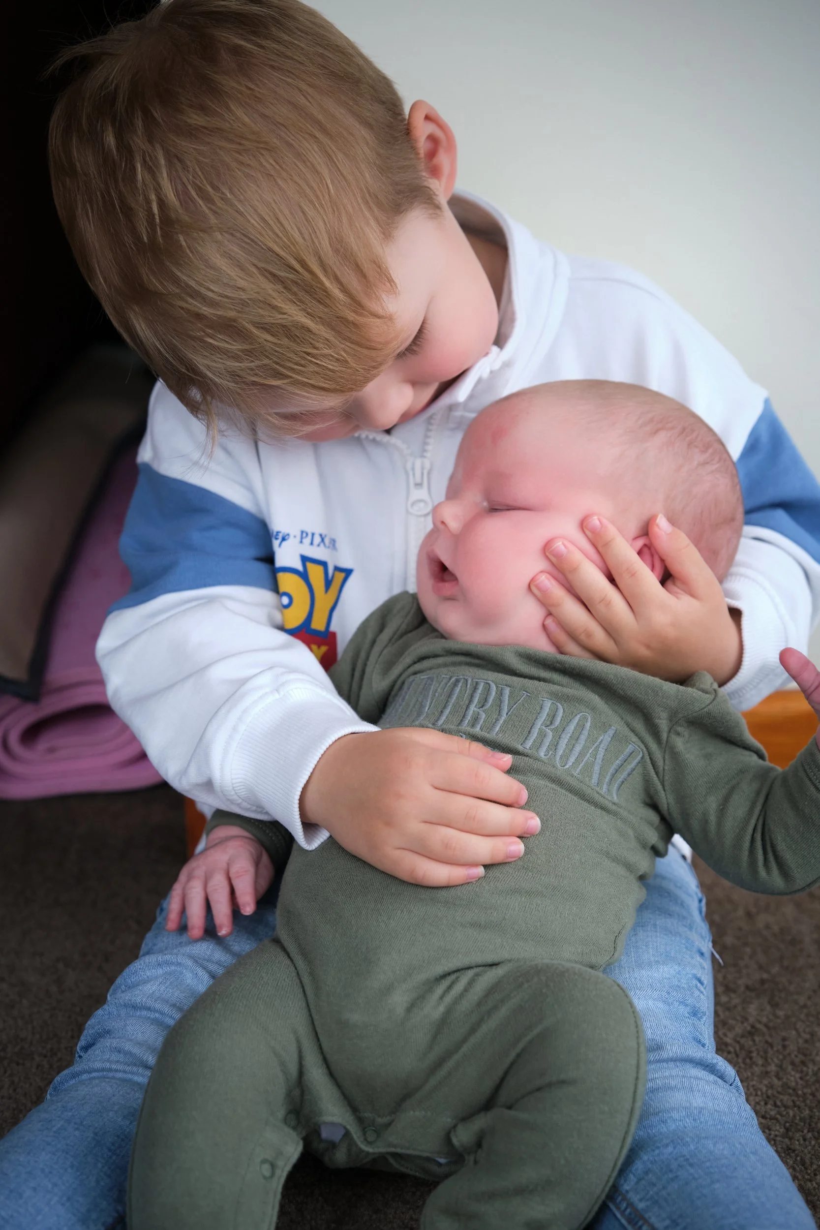 lawrence-launceston-newborn-family-photography-big-brother-cuddling-sleeping-baby.jpeg