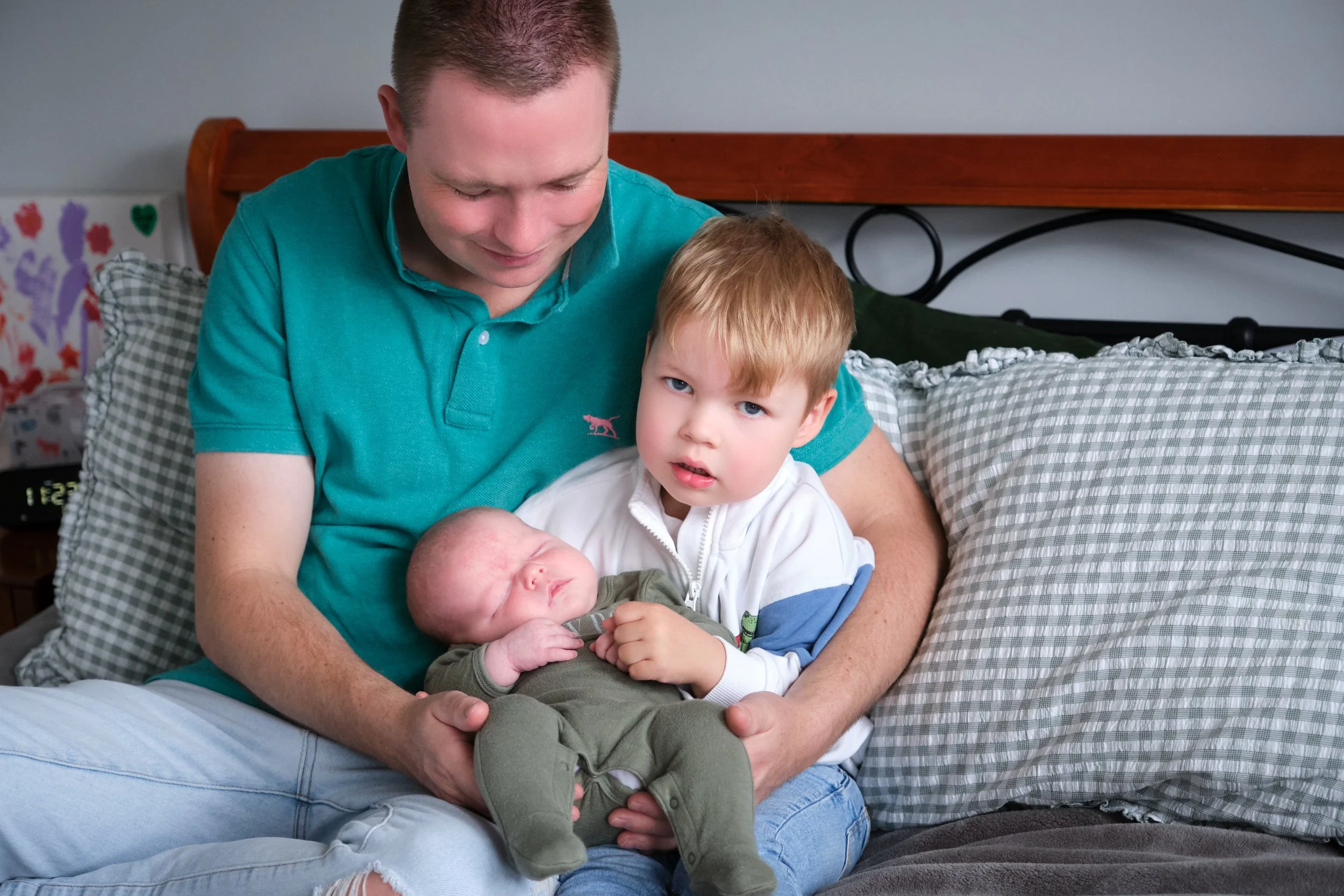 lawrence-launceston-newborn-family-photography-dad-holding-toddler-and-newborn-on-bed.jpeg