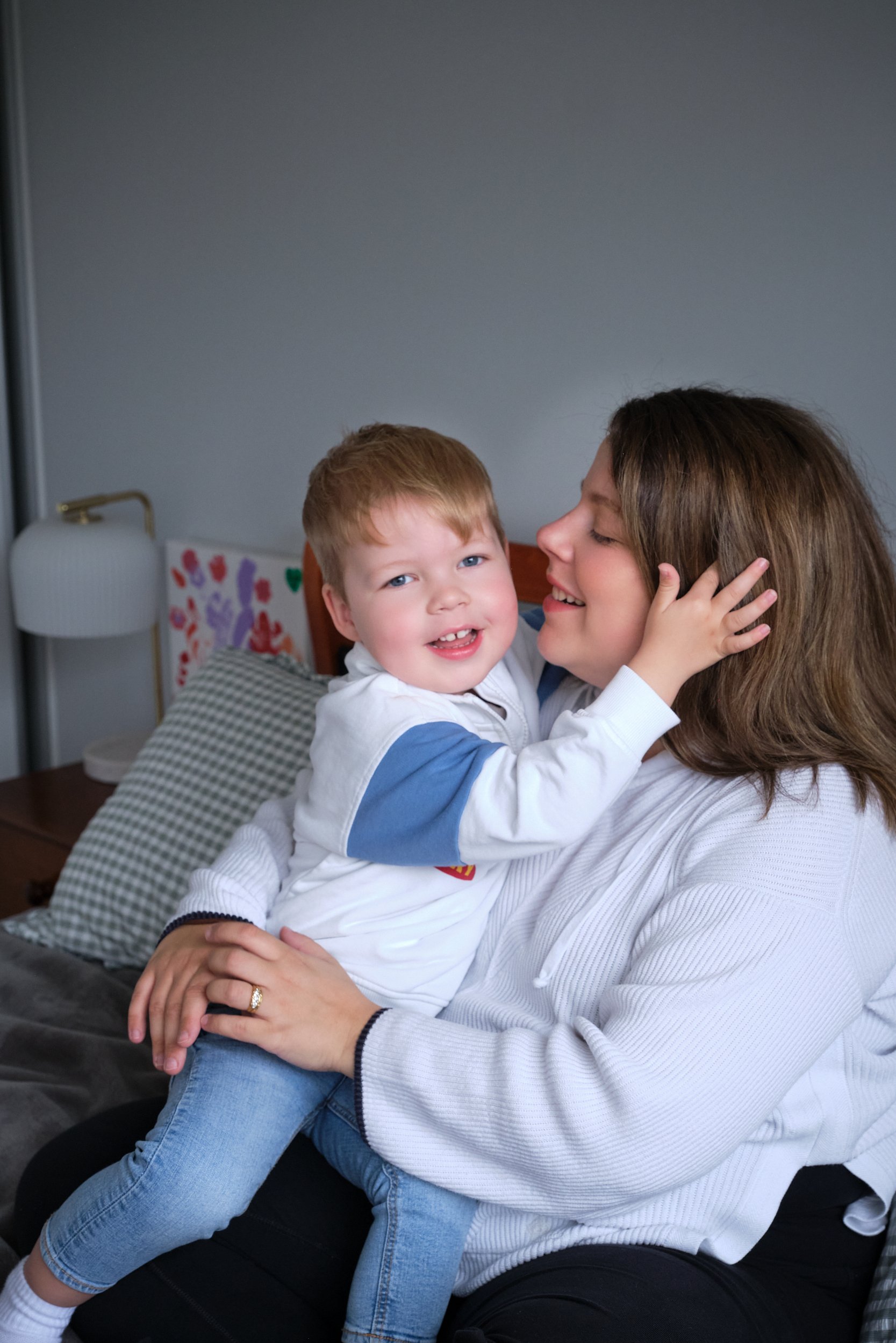 lawrence-launceston-newborn-family-photography-mum-hugging-smiling-toddler-on-bed.jpeg