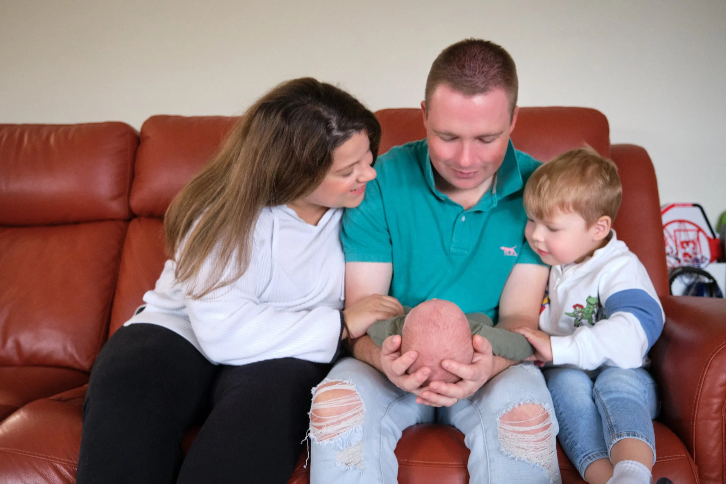 lawrence-launceston-newborn-family-photography-parents-and-toddler-admiring-new-baby.jpeg