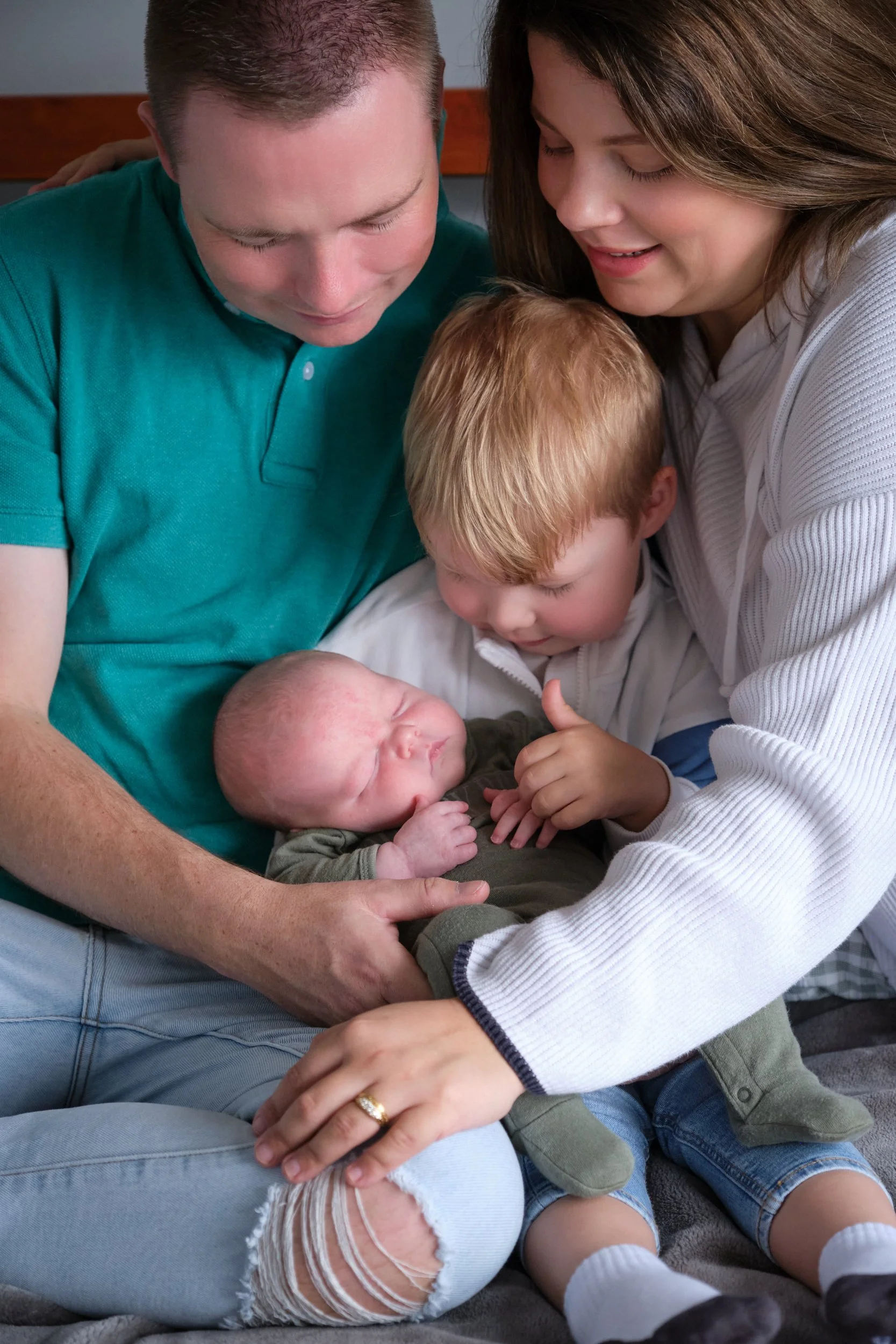 lawrence-launceston-newborn-family-photography-parents-cuddling-toddler-holding-baby.jpeg