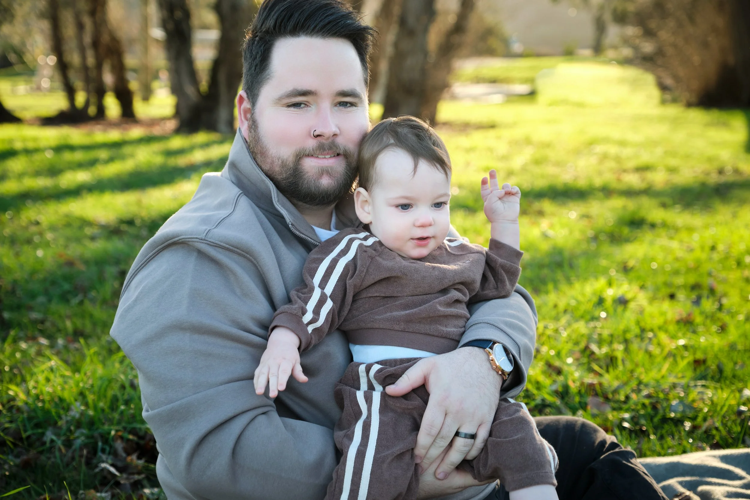 williams-hadspen-river-launceston-family-portrait-dad-holding-baby-in-sunny-park.jpeg