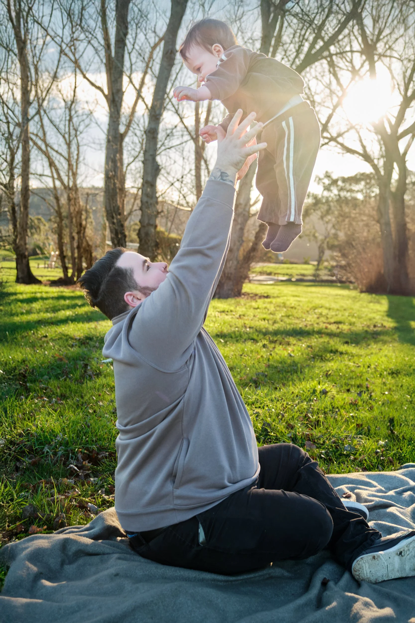 williams-hadspen-river-launceston-family-portrait-dad-lifting-baby-in-sunset-park.jpeg