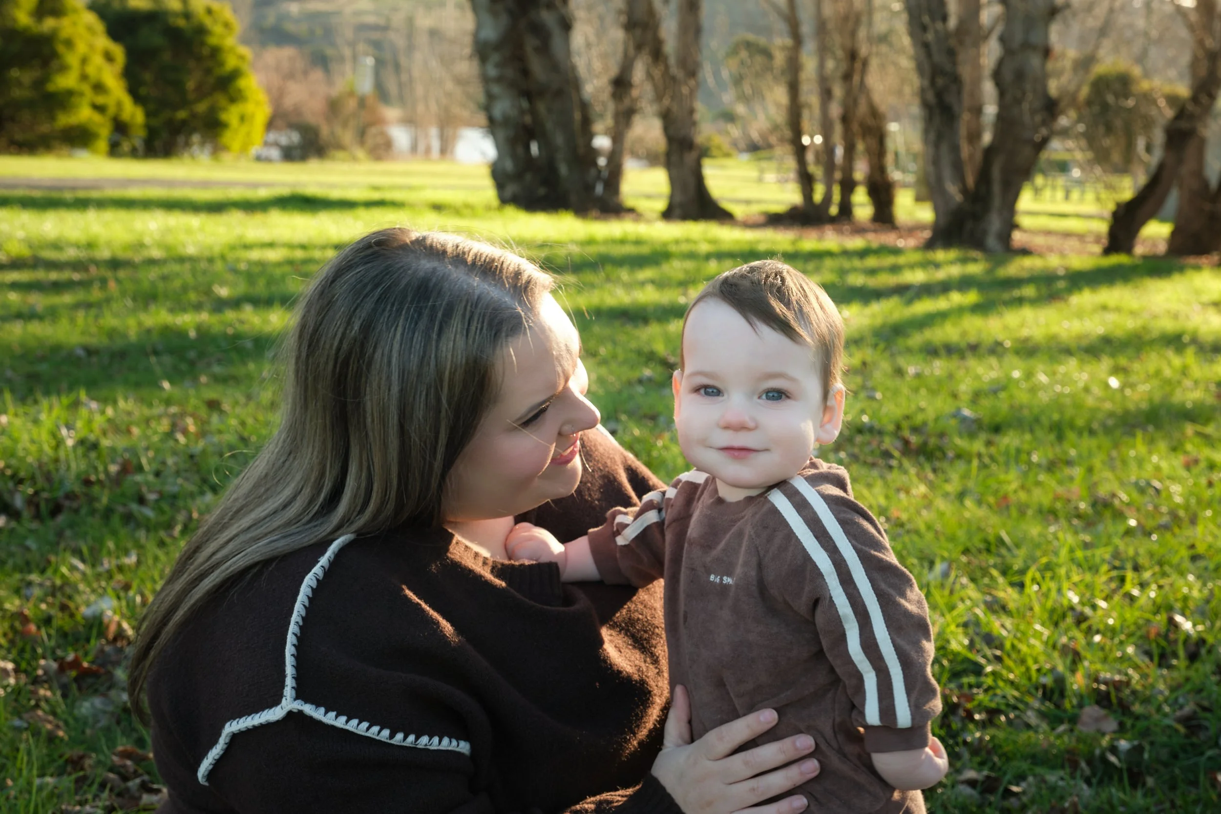 williams-hadspen-river-launceston-family-portrait-mother-holding-smiling-baby-in-park.jpeg