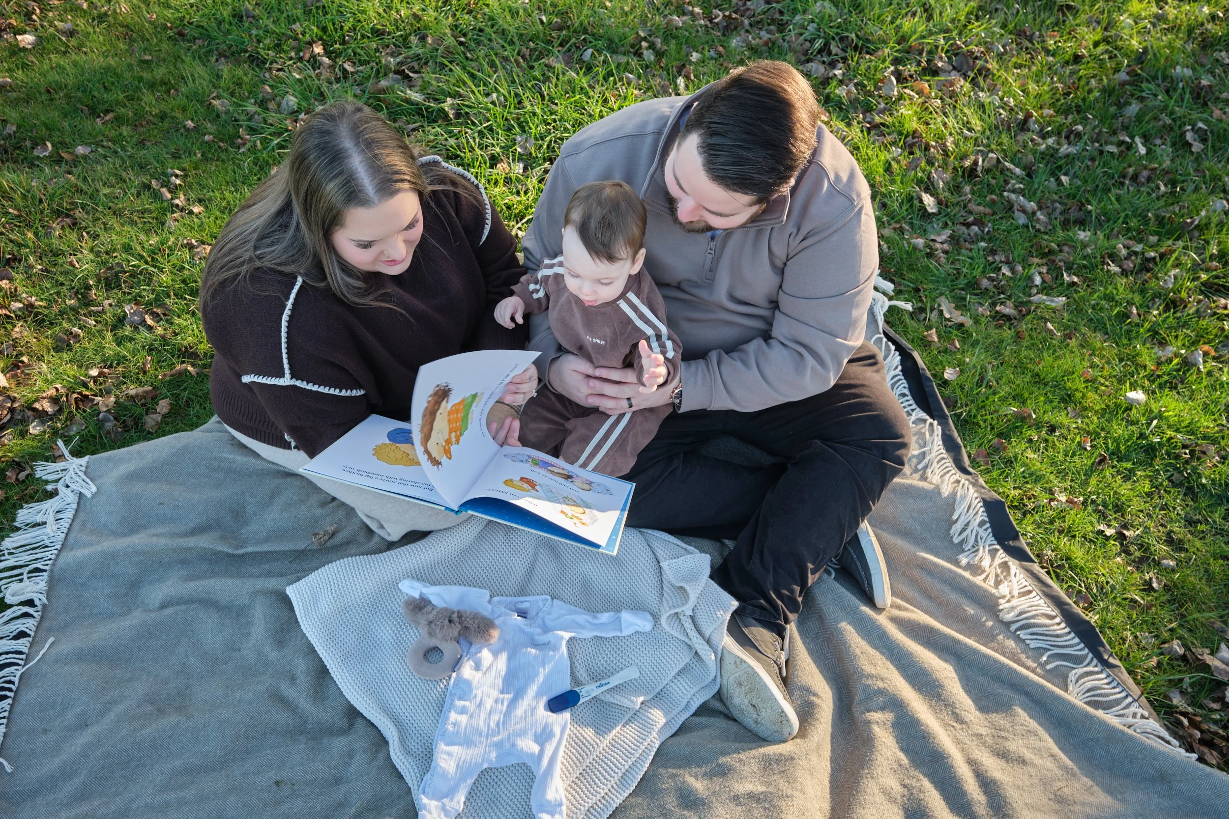 williams-hadspen-river-launceston-family-portrait-session-parents-reading-to-baby-on-blanket.jpeg