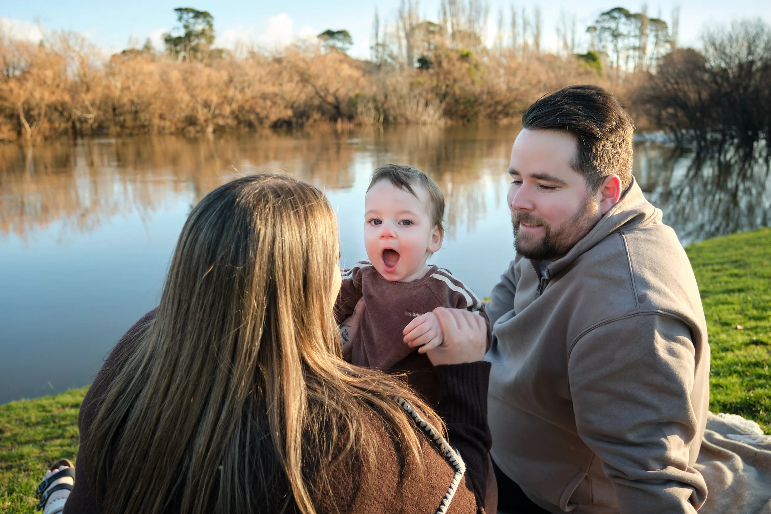 williams-hadspen-river-launceston-family-portrait-session-parents-with-baby-by-riverside.jpeg