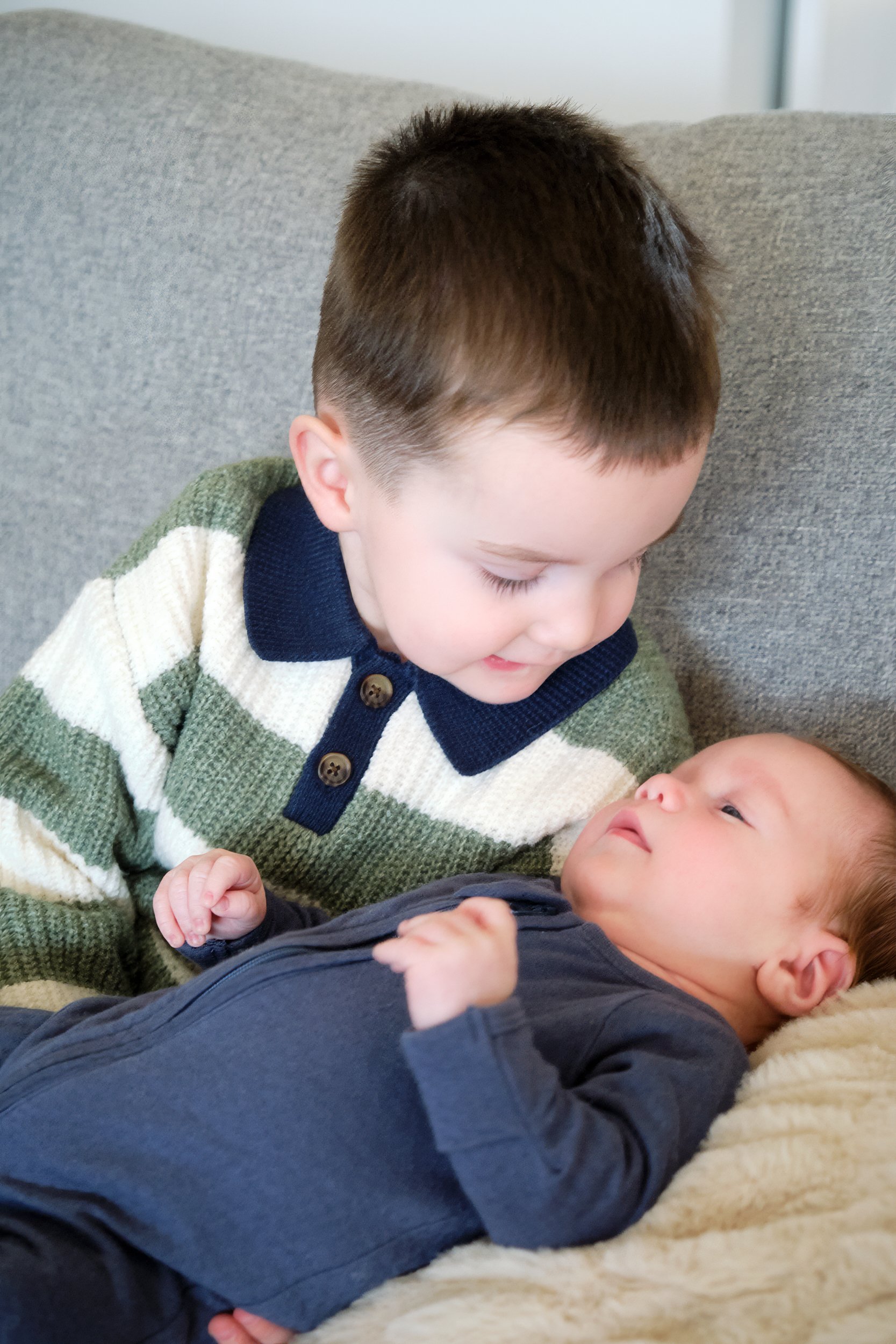 hill-launceston-newborn-family-photography-big-brother-holding-newborn-baby-couch.jpeg