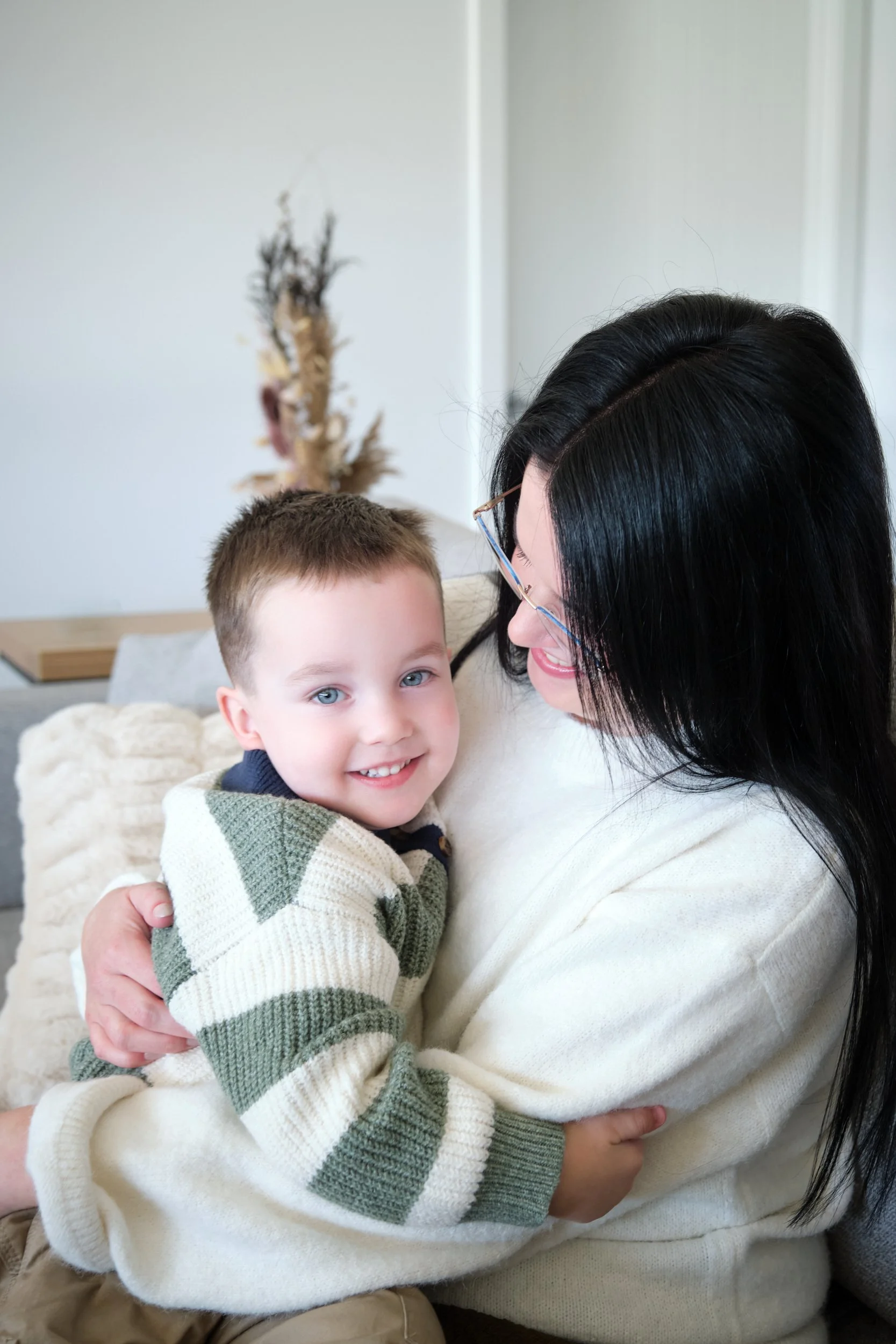 hill-launceston-newborn-family-photography-mum-cuddling-smiling-toddler-on-couch.jpeg