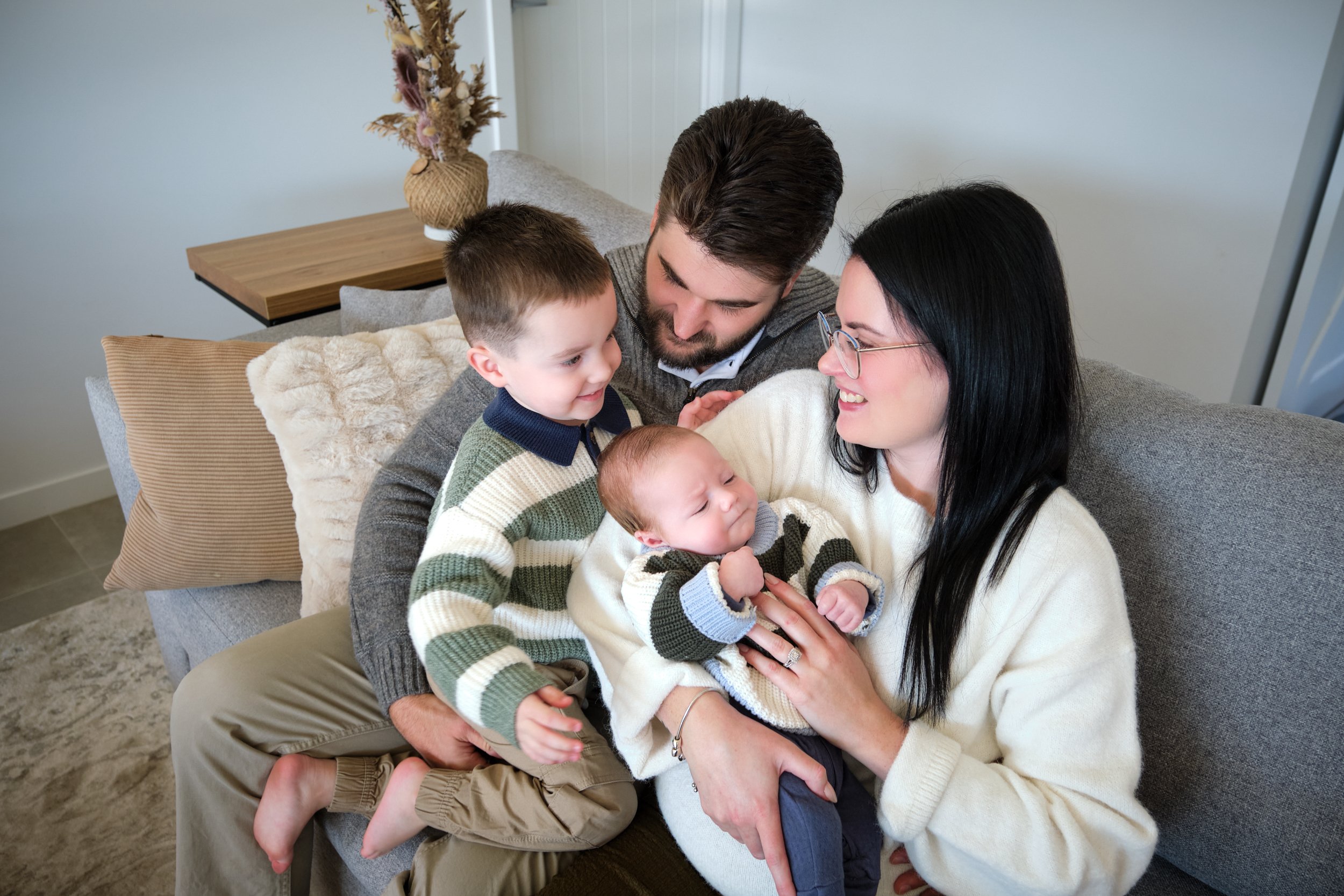 hill-launceston-newborn-family-photography-parents-cuddling-toddler-and-baby-on-couch.jpeg
