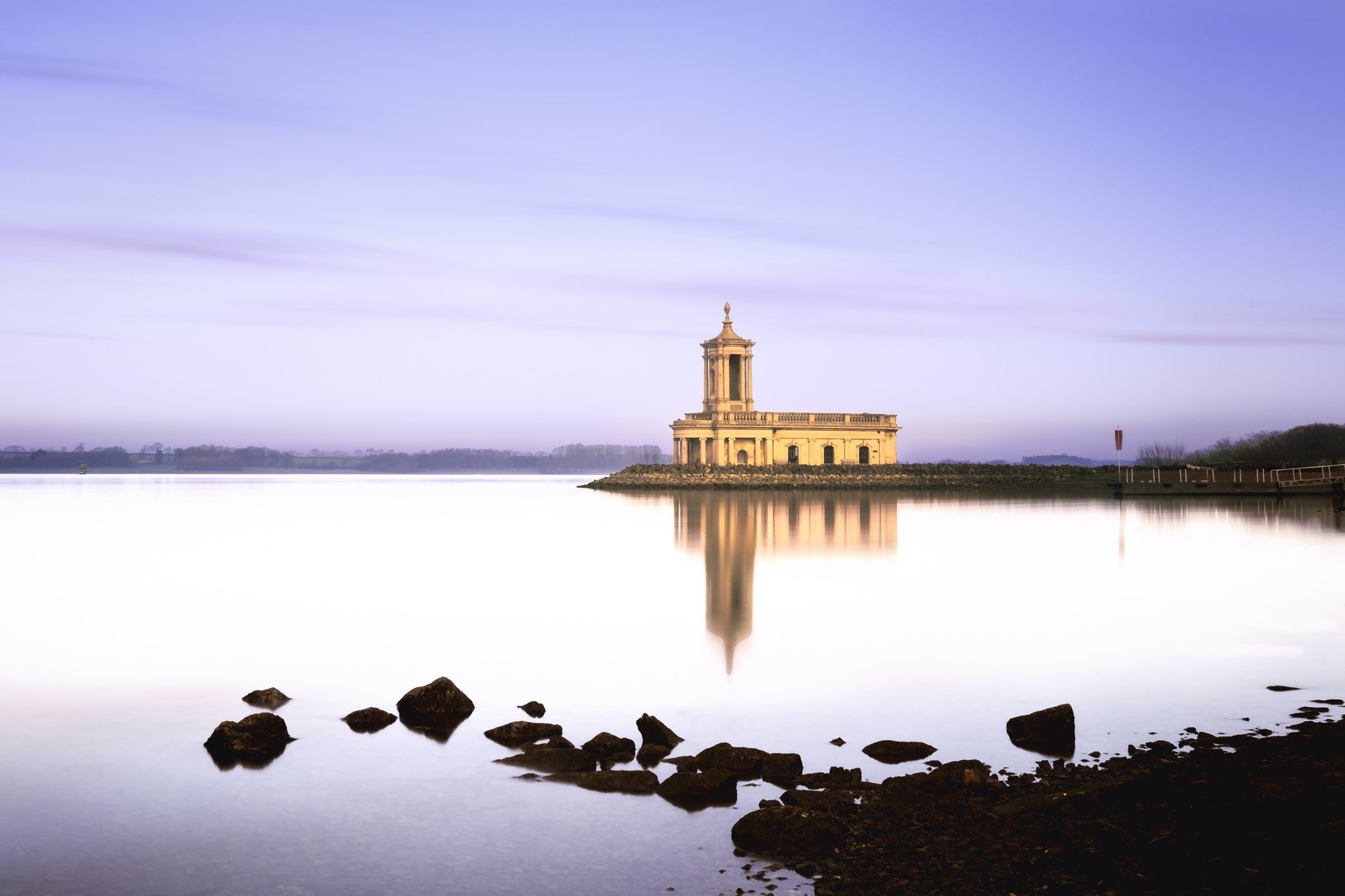 Normanton Church lit in pale lavender and gold during a quiet early morning