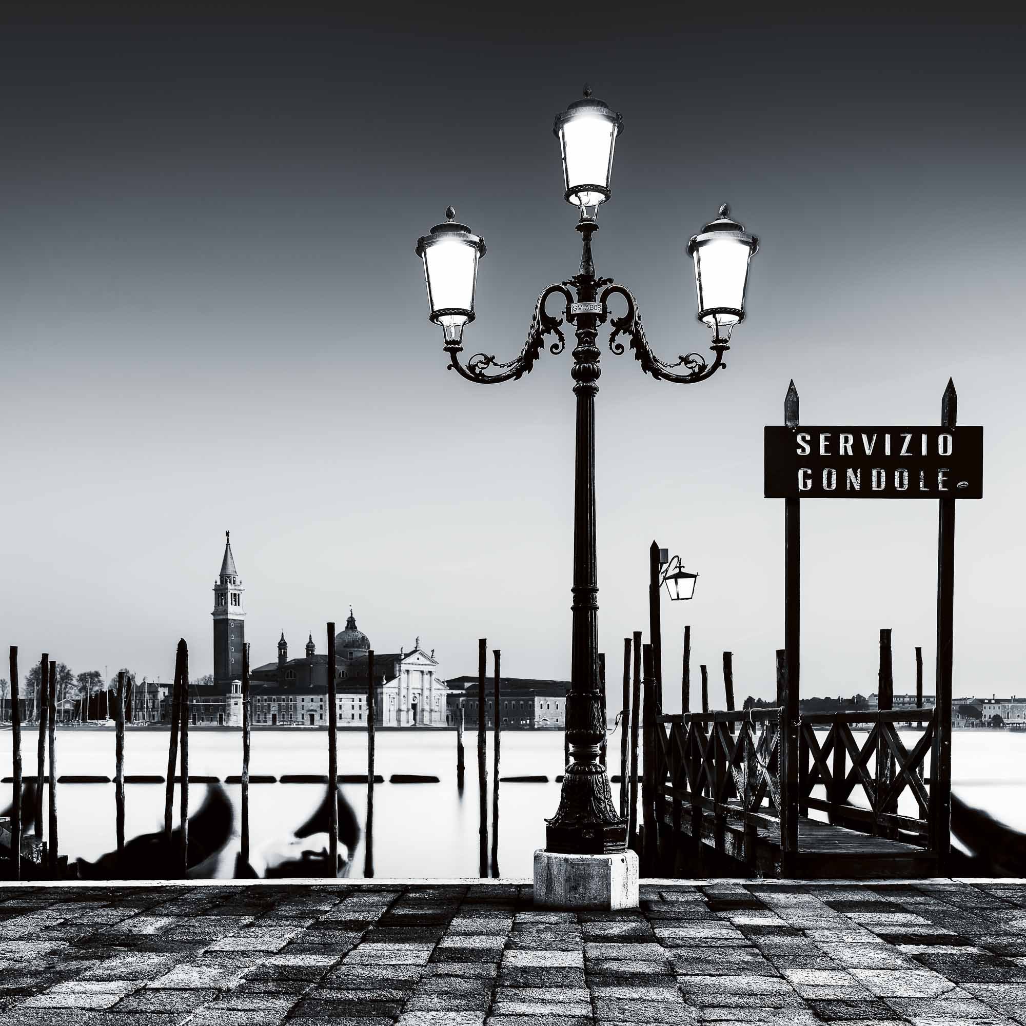 Black and white photograph of a quiet gondola scene in Venice, evoking timeless calm.