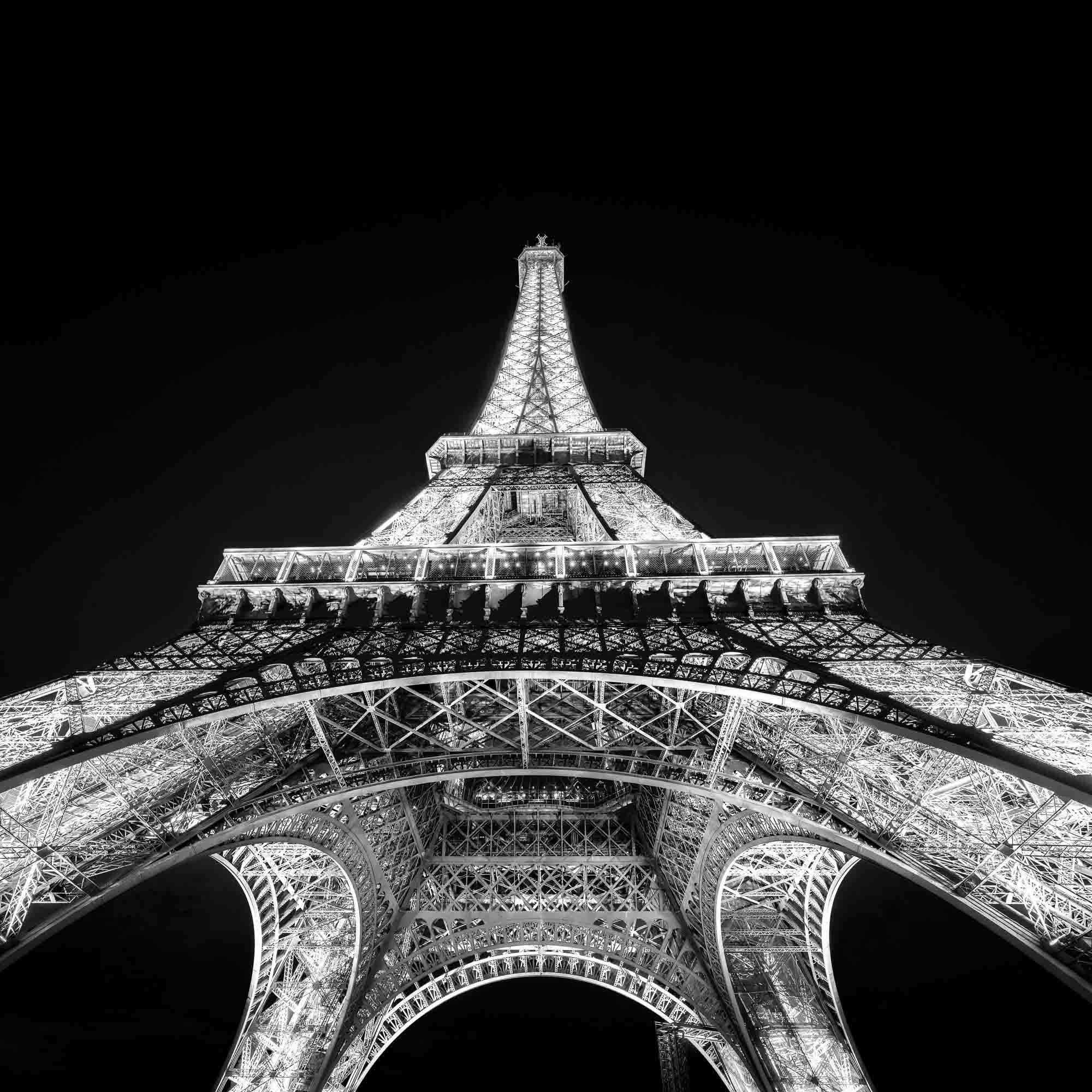 Dramatic black and white view from beneath the Eiffel Tower—geometric grandeur.