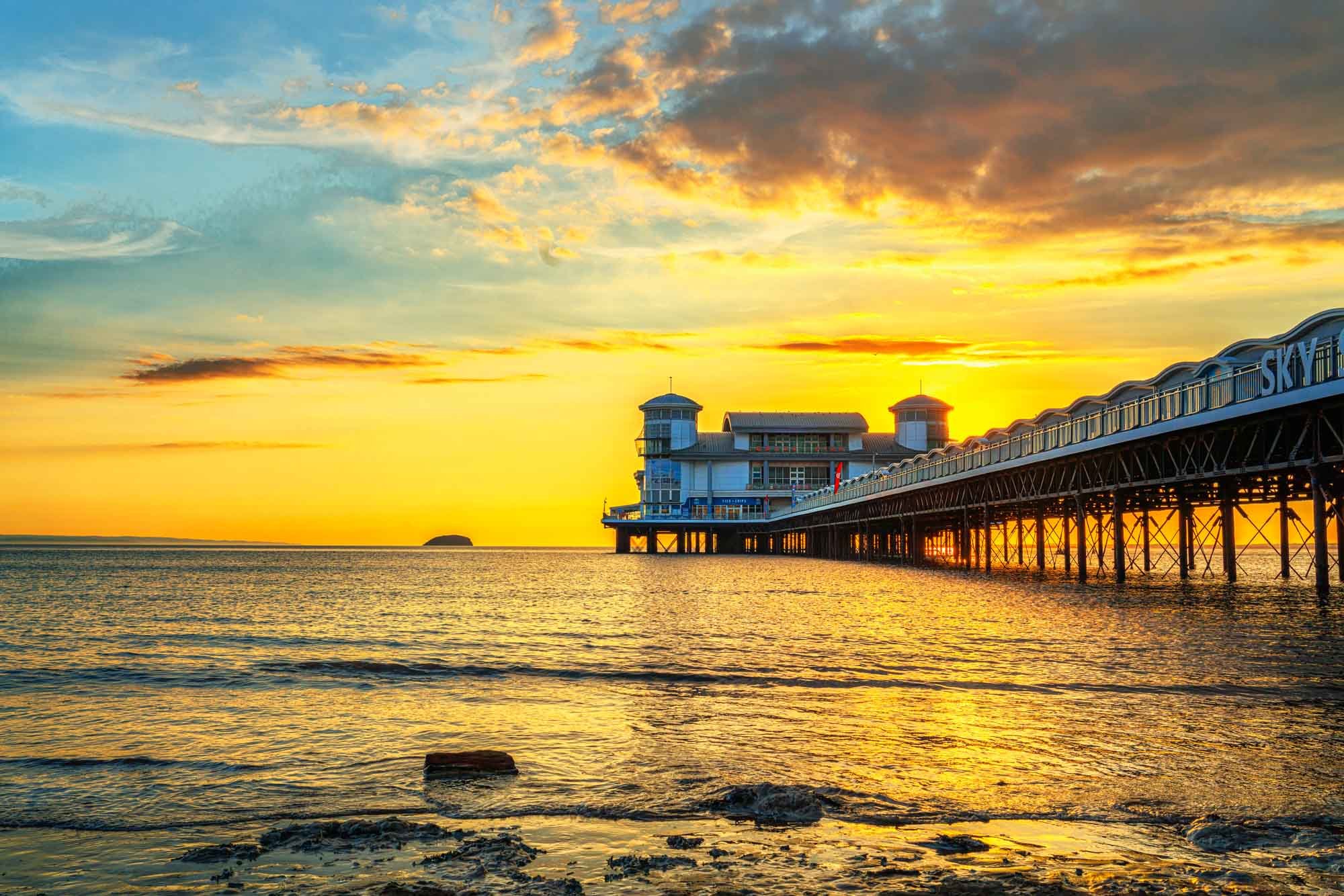 Sunset over the pier in Weston-super-Mare, Somerset, casting golden light on the sea