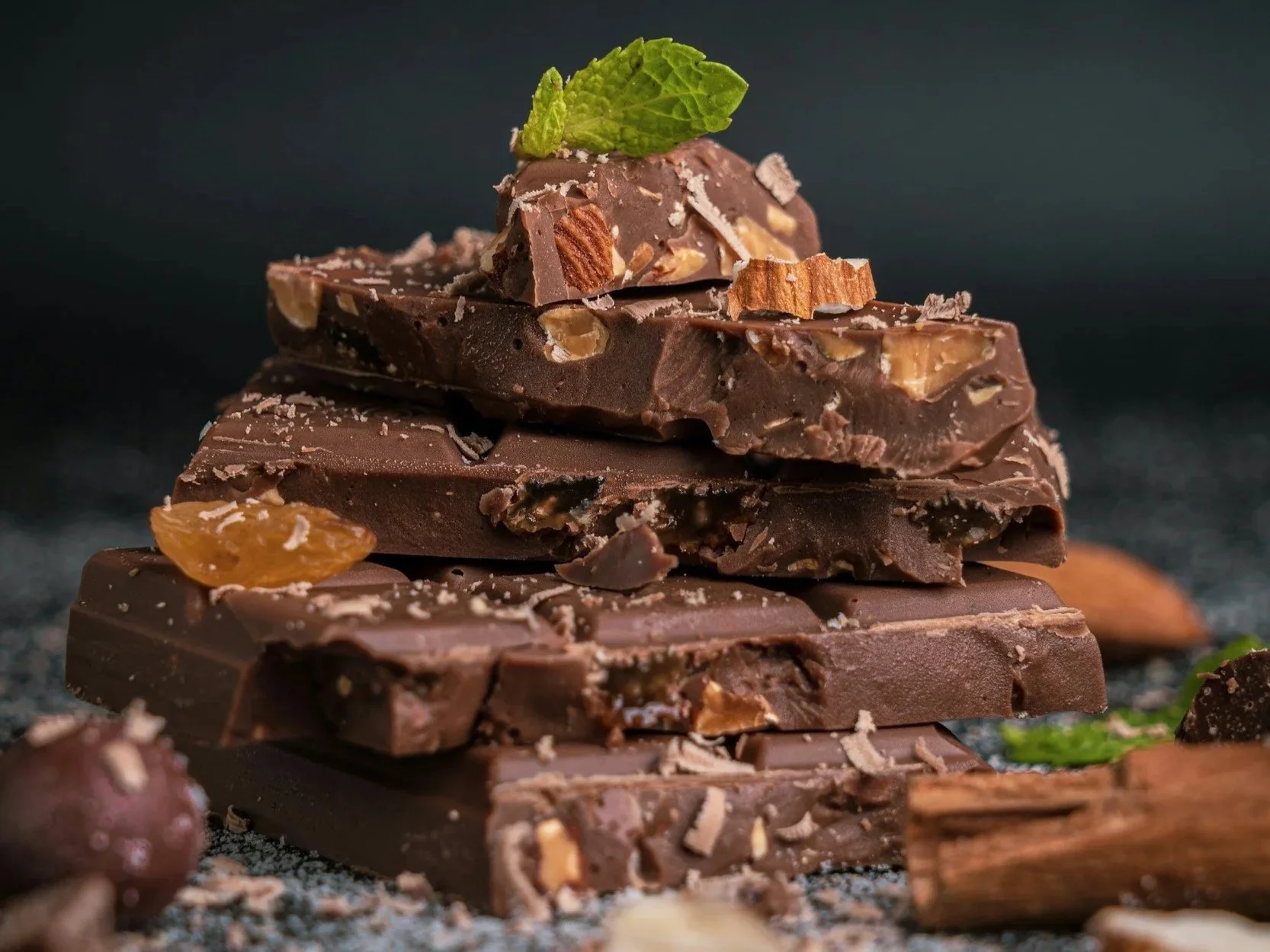A roughly chopped stack of chocolate reveals crystallised ginger and almonds, and is topped with a small mint leaf.