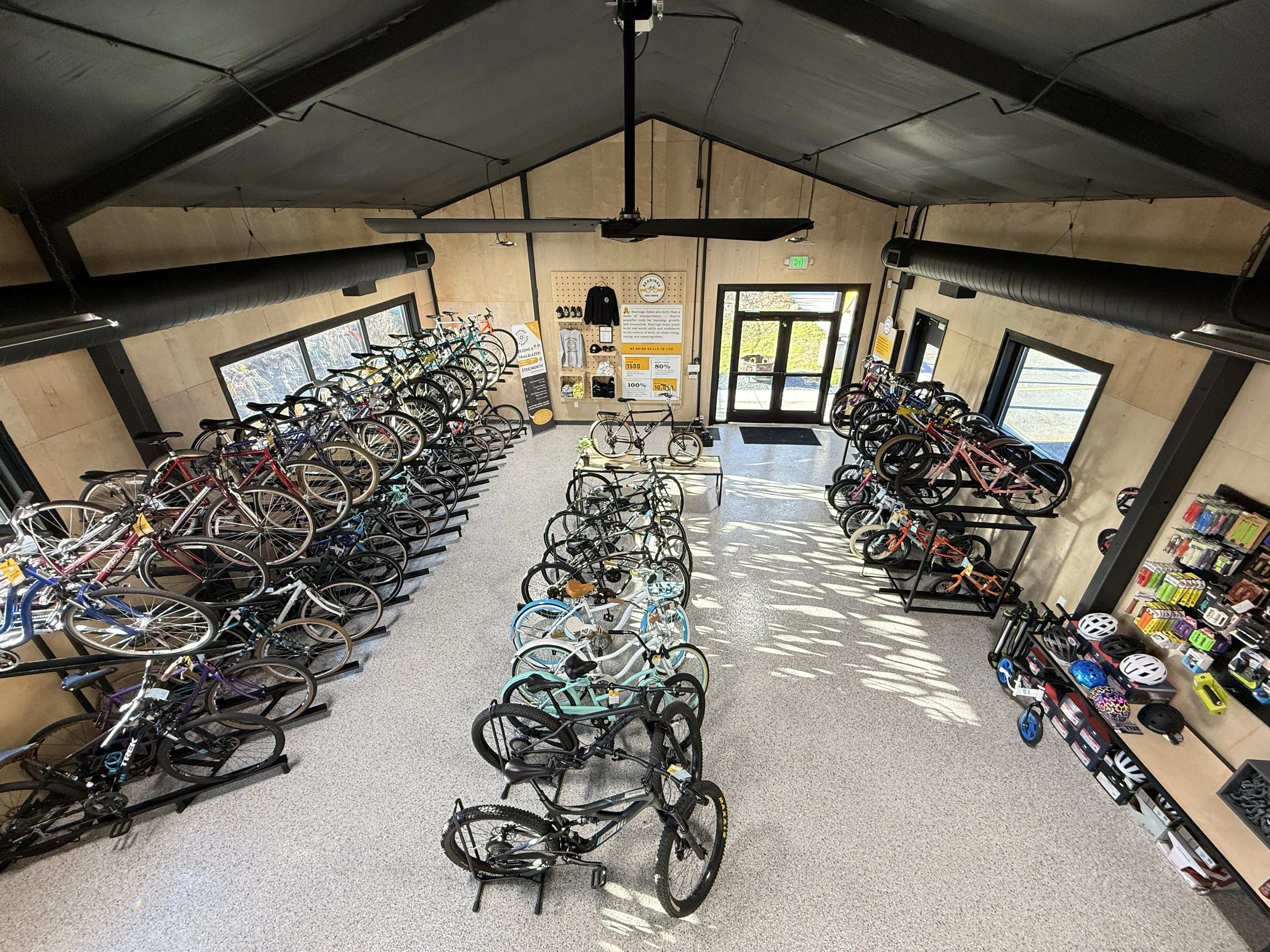Interior of a bike shop or rental shop with various bicycles on display, including adult and children's bikes, helmets, and accessories.