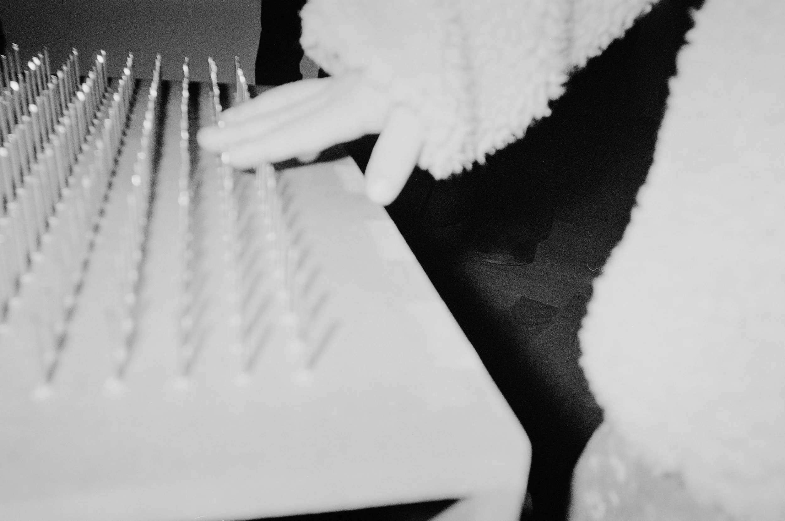 A person in a fluffy sweater playing the piano, with their hands on the keys.