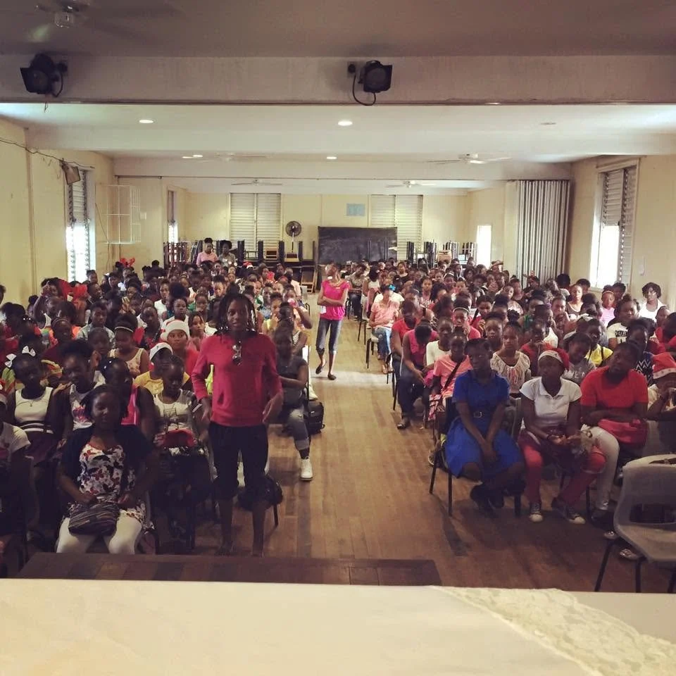 Members of the student body at the opening session on gender-based violence with our co-founder, Sarah-Anne Gresham, the Acting Director of Gender Affairs Ms. Farmala Jacobs, and Kyla Burton for Girls' Day at the Antigua Girls High School in 2015.