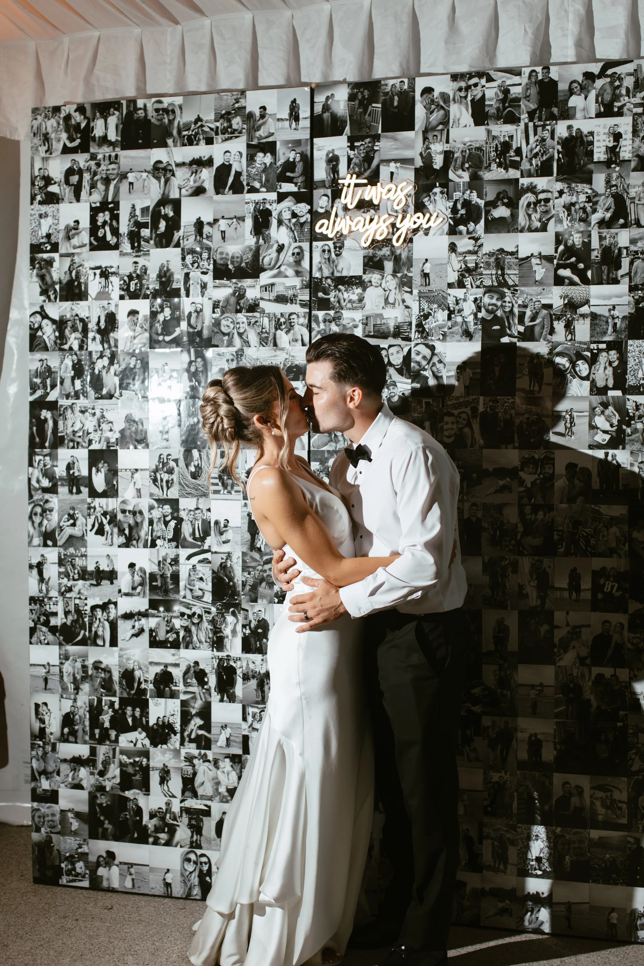 Wedding couple with a black and white photo wall